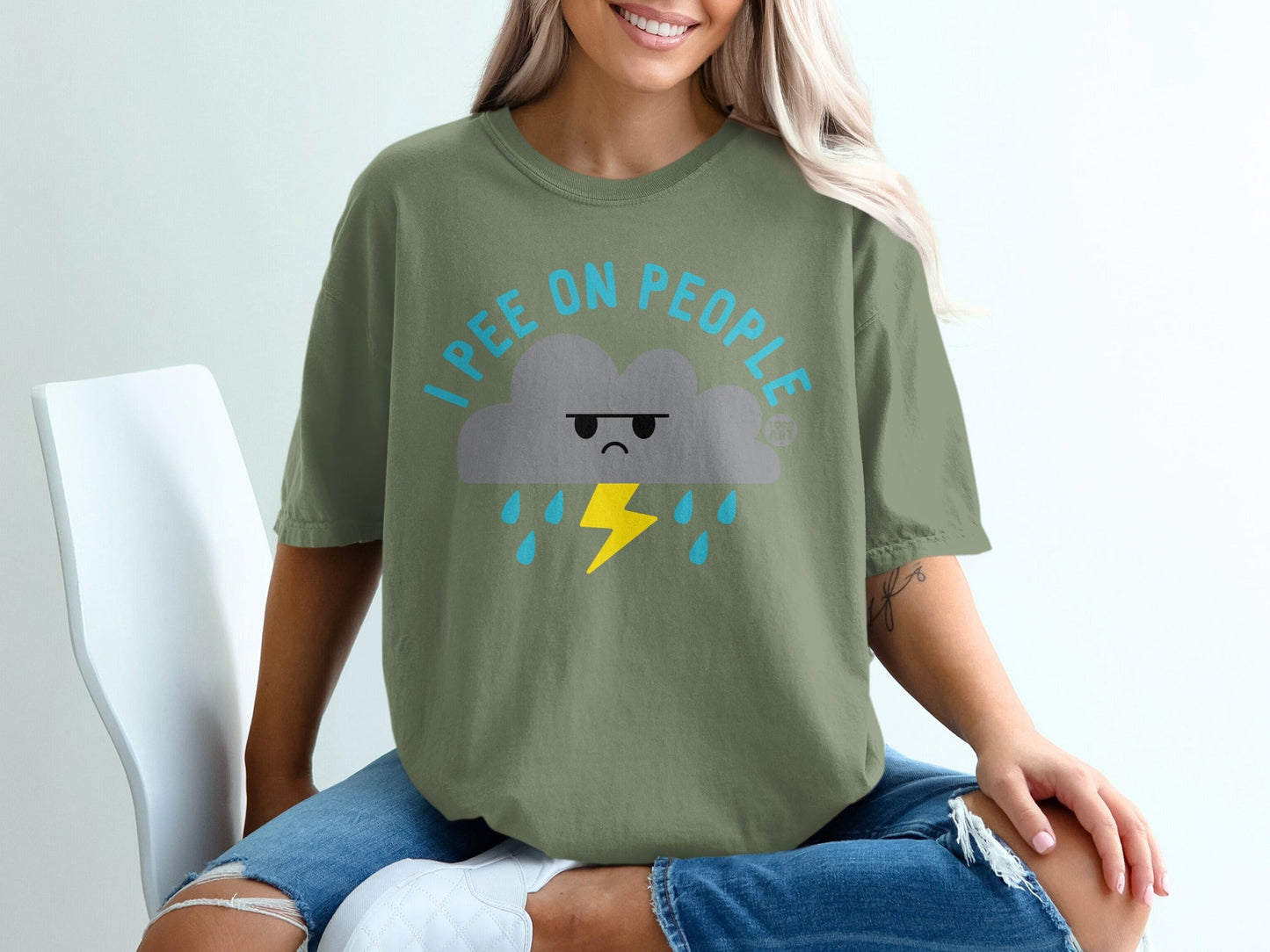 Green t-shirt with a cartoon cloud and lightning bolt graphic that reads "I PEE ON PEOPLE."