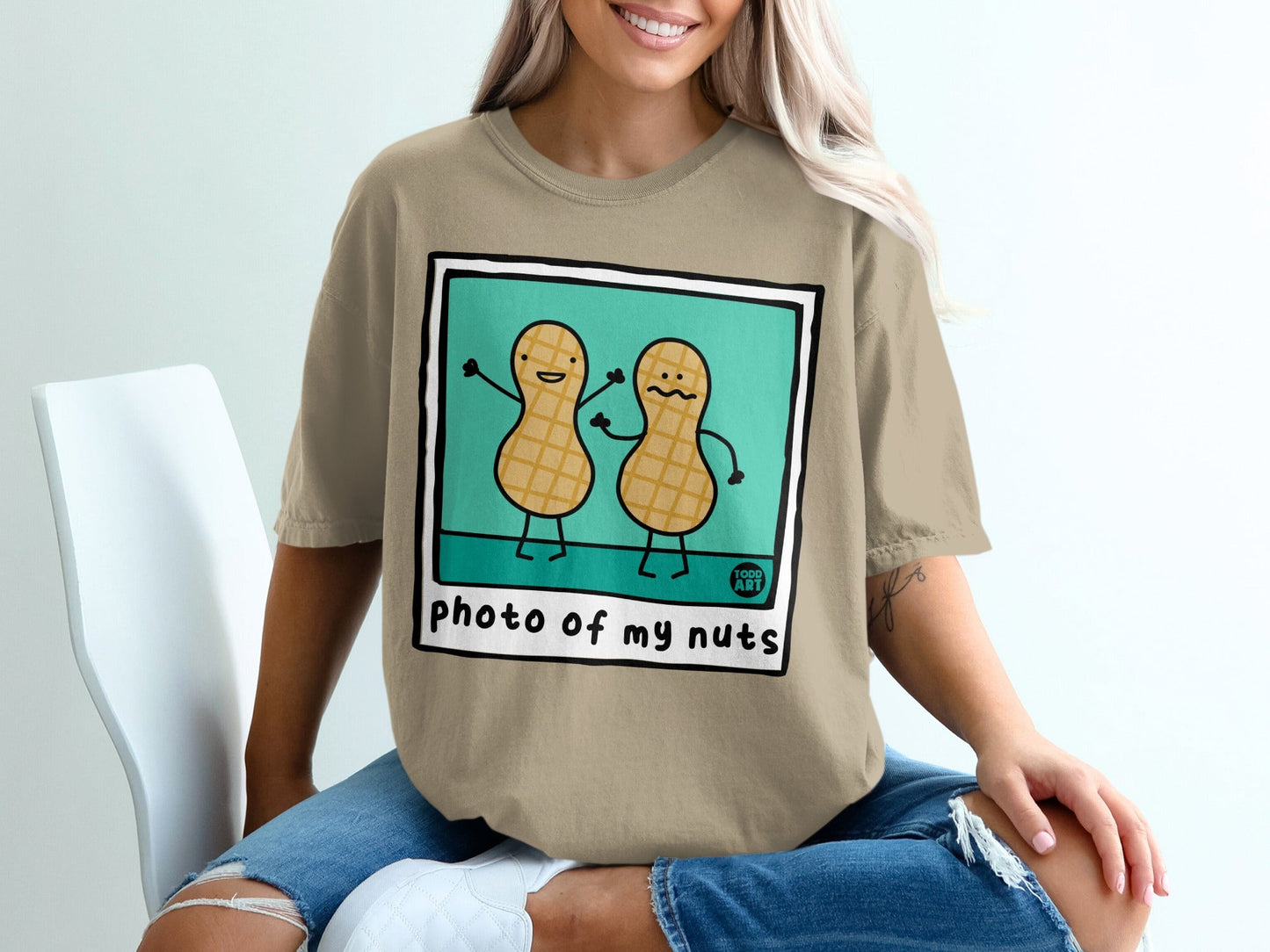 Two cartoon peanuts with arms raised, wearing shirts that say "photo of my nuts"