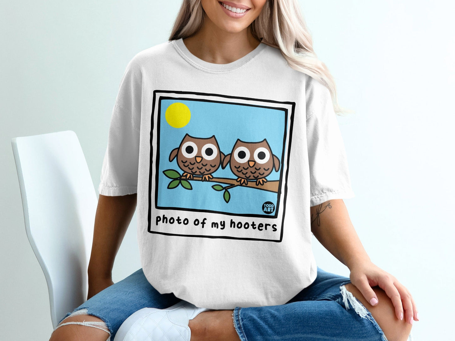 Two cartoon owls perched on a branch under a sun, text "photo of my hooters"