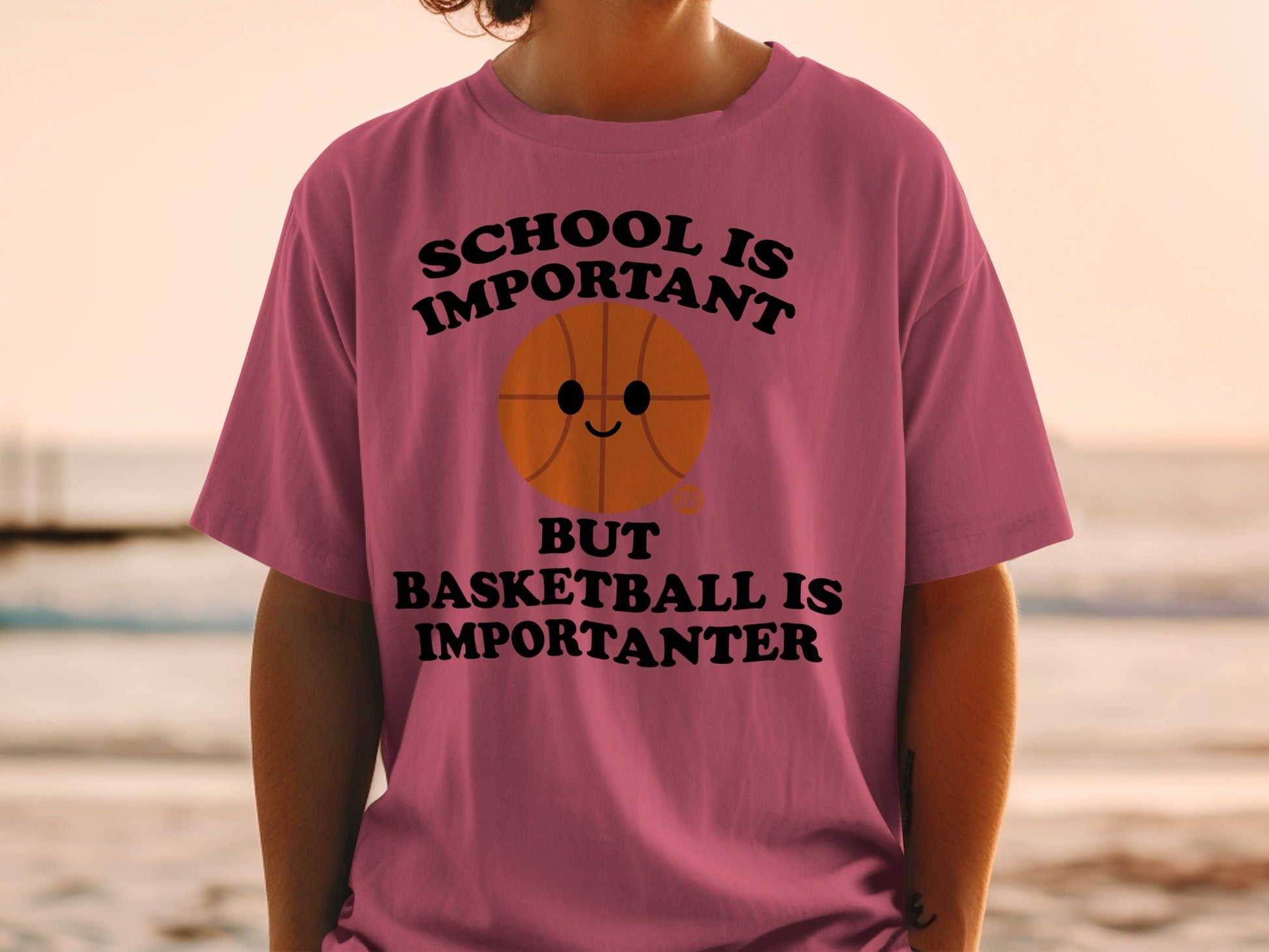 Pink t-shirt with "SCHOOL IS IMPORTANT BUT BASKETBALL IS IMPORTANTER" and a smiling basketball.