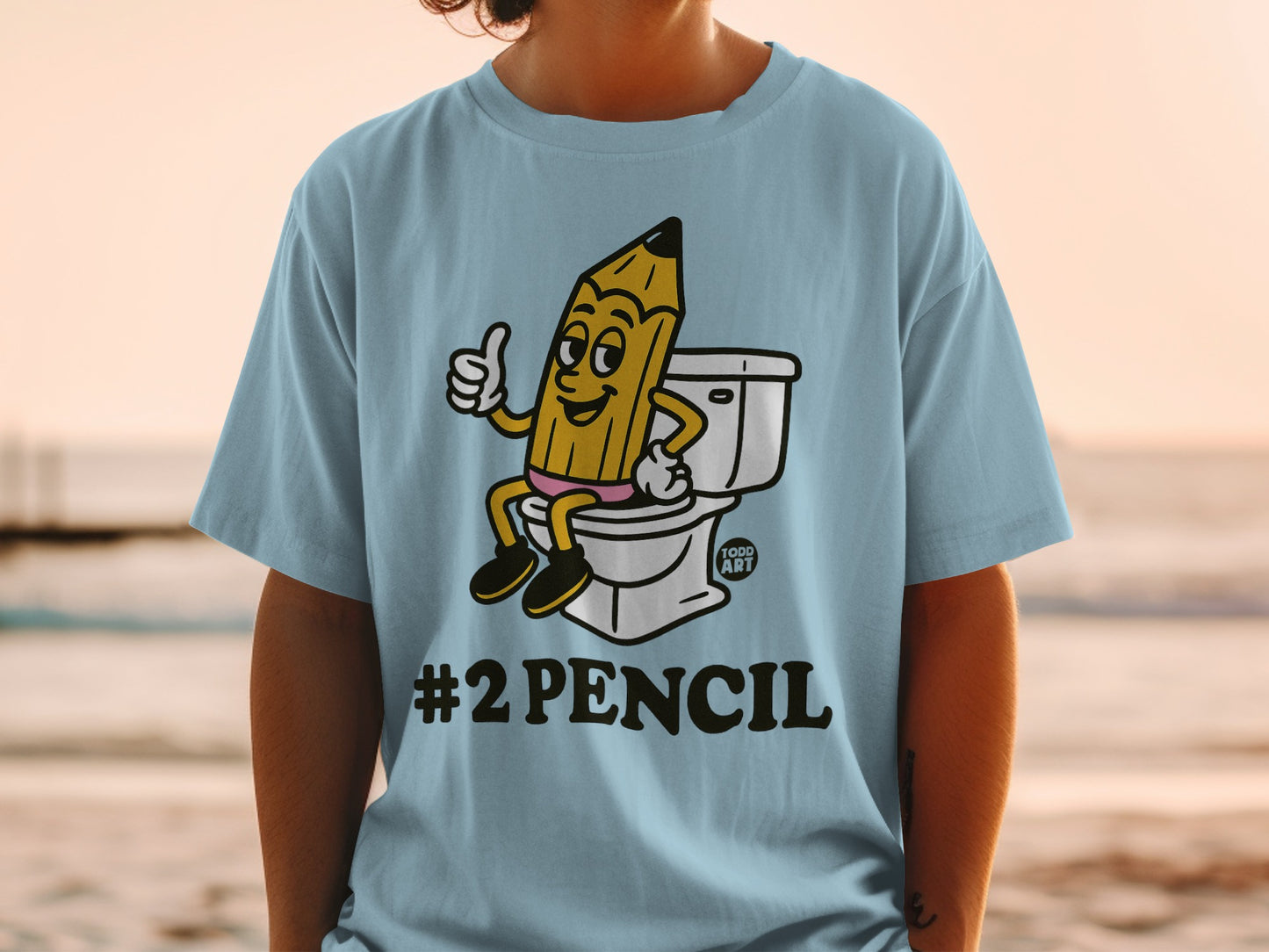 Light blue t-shirt with cartoon pencil on toilet, thumbs up, "#2 PENCIL" text.