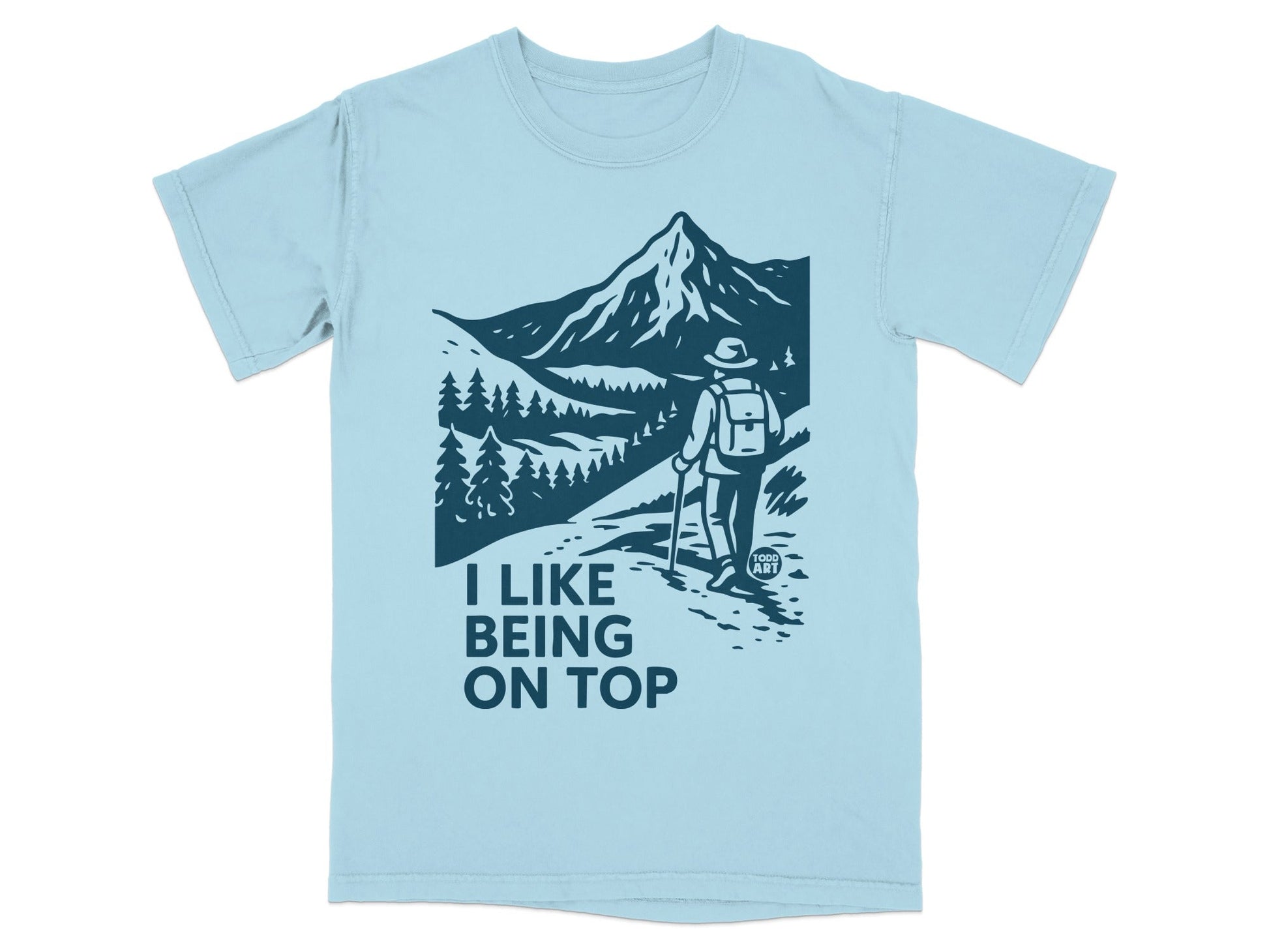 Light blue t-shirt with a mountain hiking graphic and text "I LIKE BEING ON TOP".