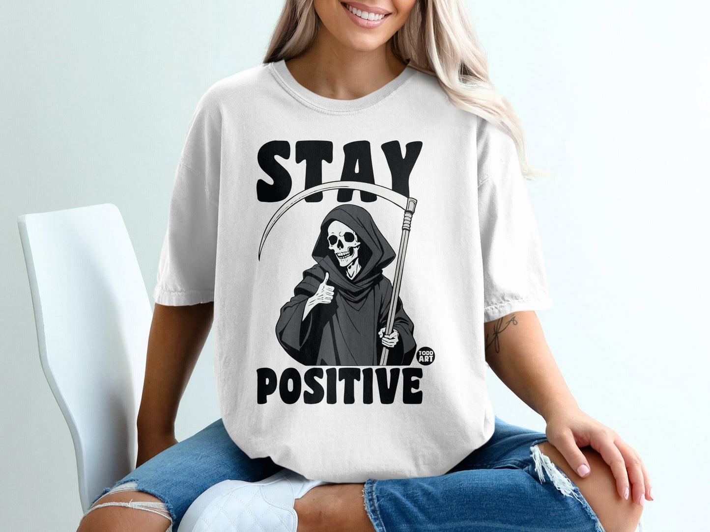 T-shirt with Grim Reaper giving thumbs up and "STAY POSITIVE" text.