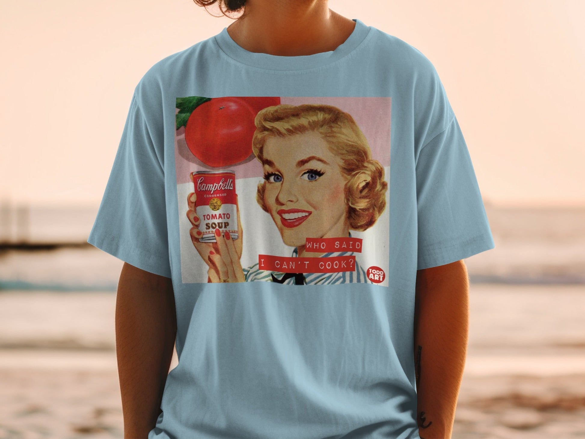Woman in blue shirt holding Campbell's Tomato Soup can, text "WHO SAID I CAN'T COOK?".