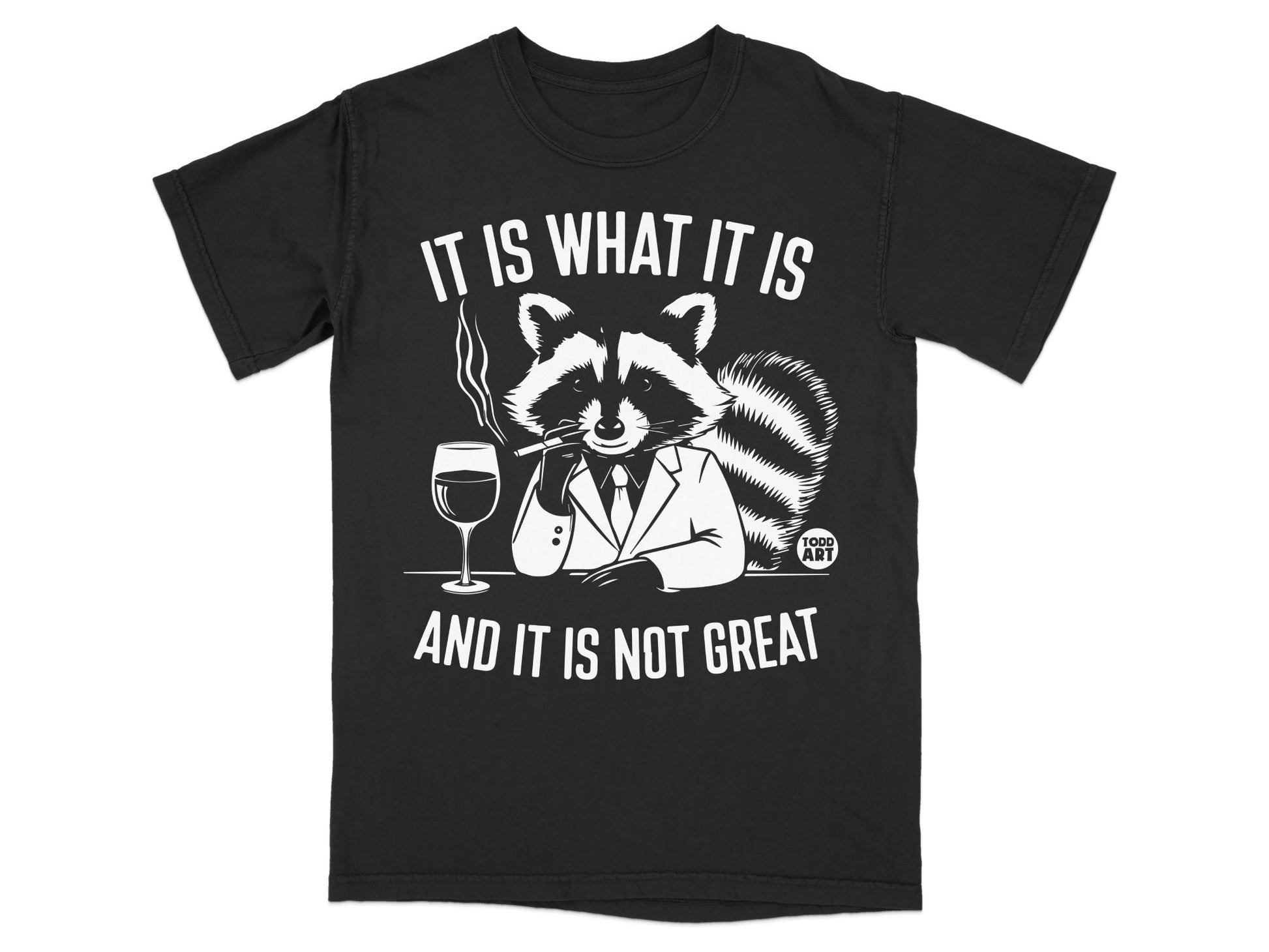 Black t-shirt with raccoon wearing suit, smoking, holding glass. Text reads "IT IS WHAT IT IS AND IT IS NOT GREAT".
