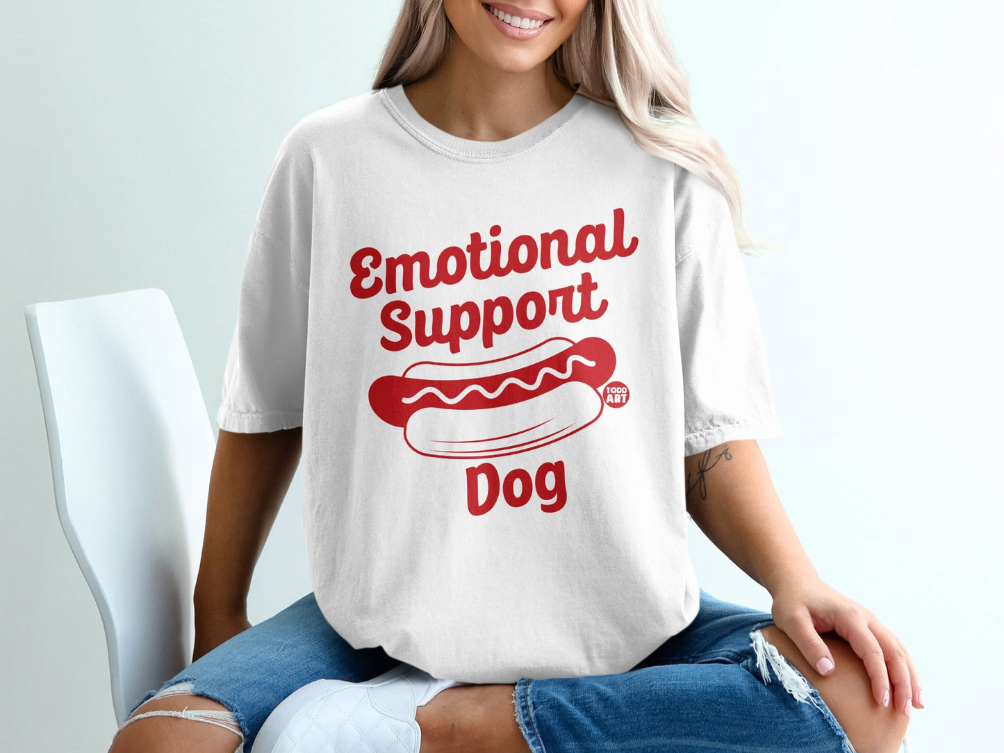White t-shirt with red text reading "Emotional Support Dog" and a hot dog graphic.
