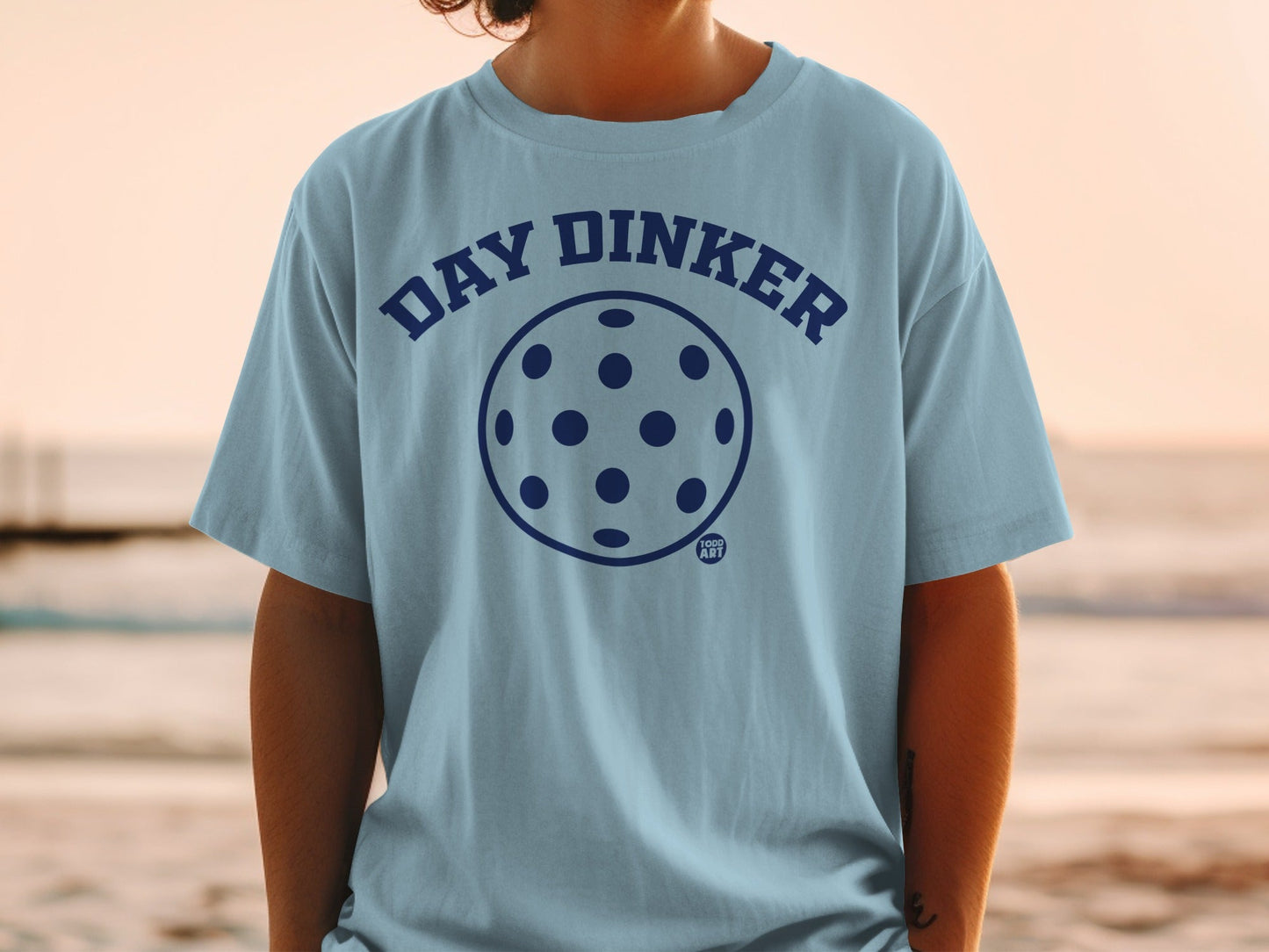 Light blue t-shirt with "DAY DINKER" and pickleball graphic.