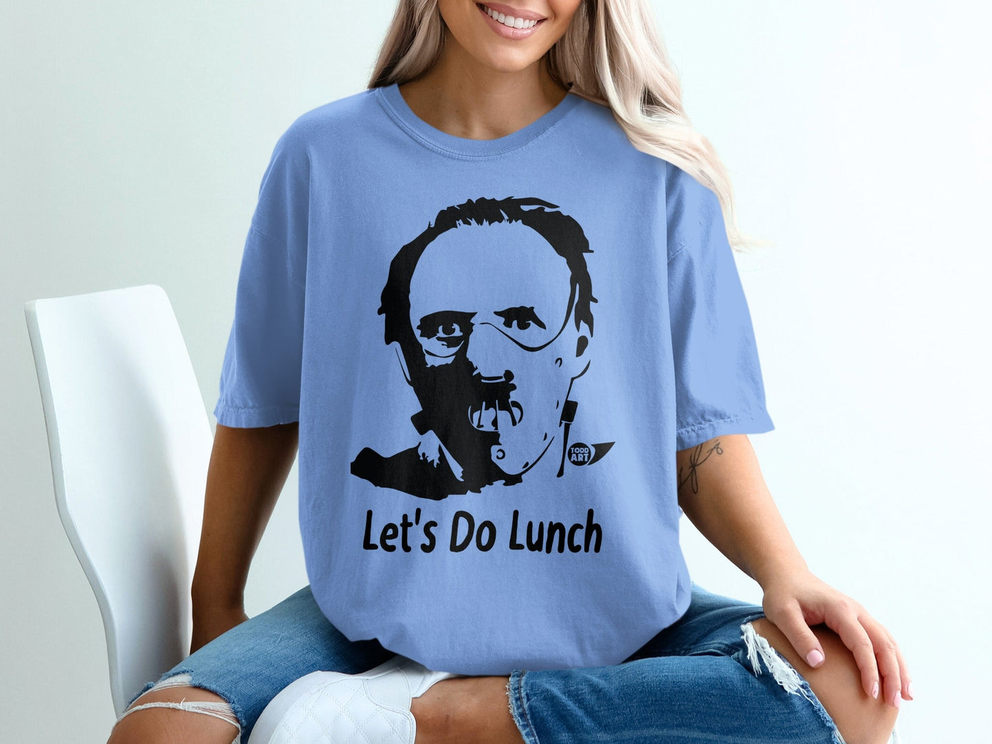 Light blue t-shirt with black graphic of Hannibal Lecter and "Let's Do Lunch" text.
