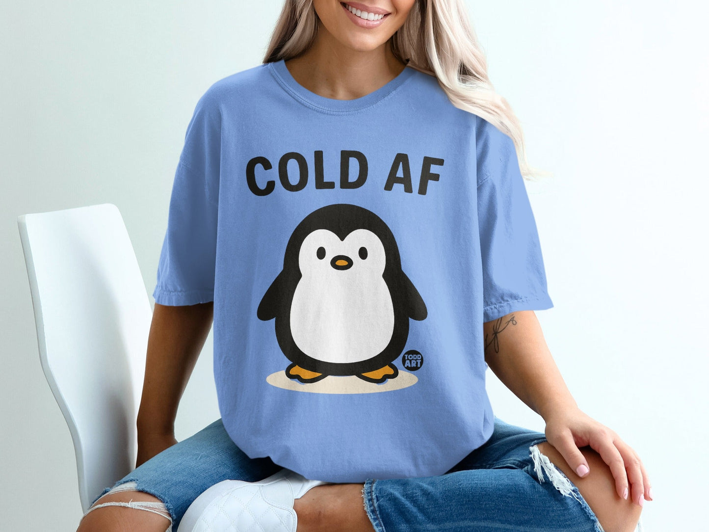 Light blue t-shirt with a cartoon penguin and "COLD AF" text.