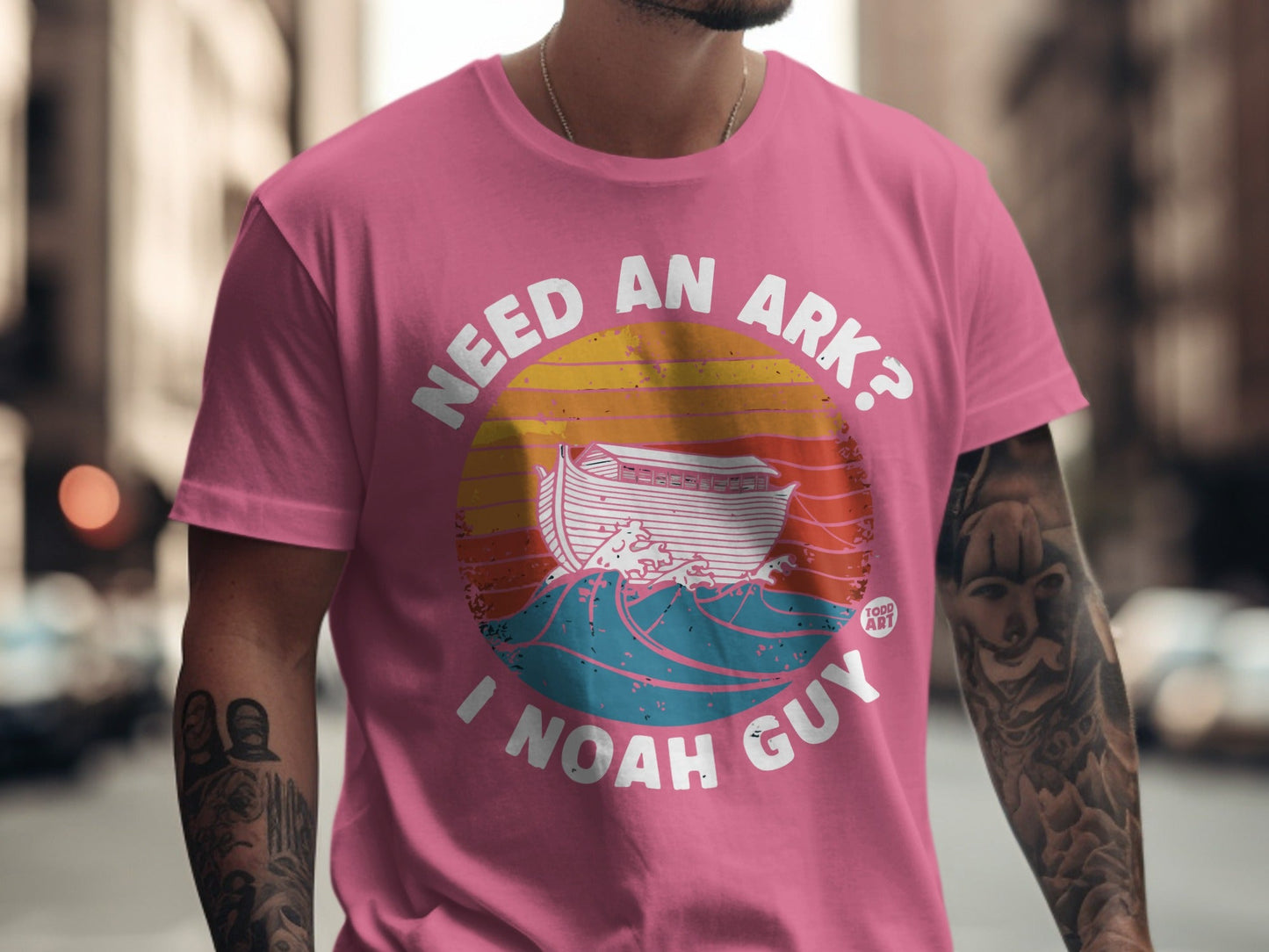 Pink t-shirt with "Need an ark? I Noah Guy" text and Noah's ark graphic.