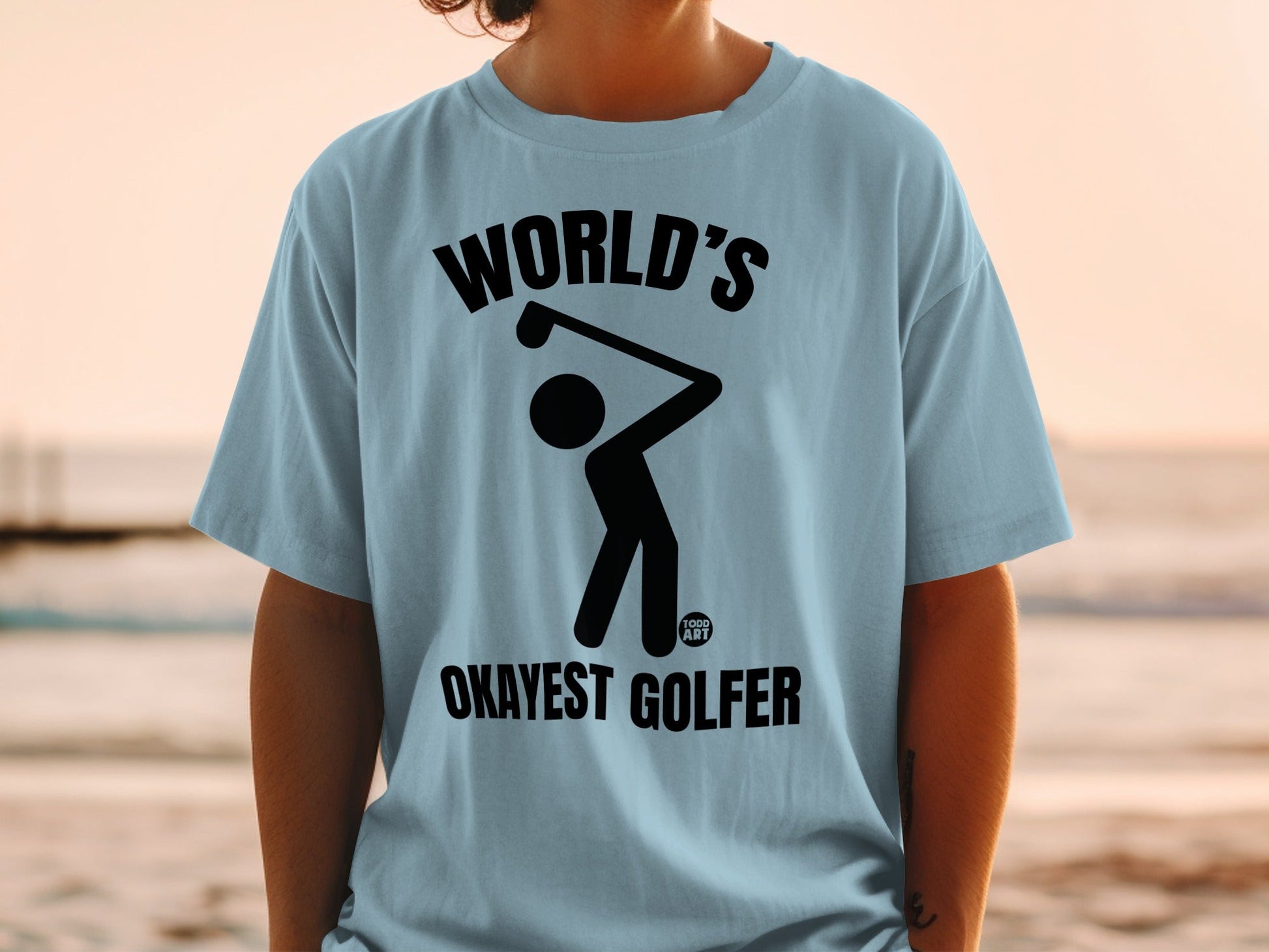 Light blue t-shirt with black text and graphic of a golfer.