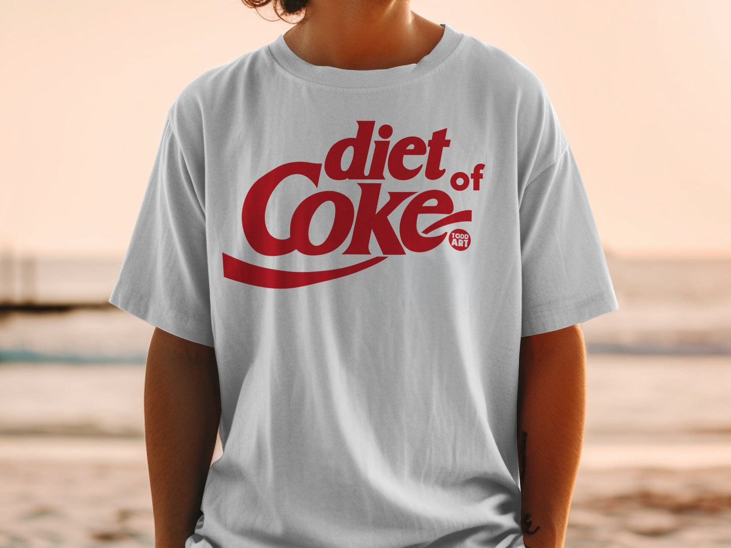 White t-shirt with red Diet Coke logo and small "1000 ART" text.