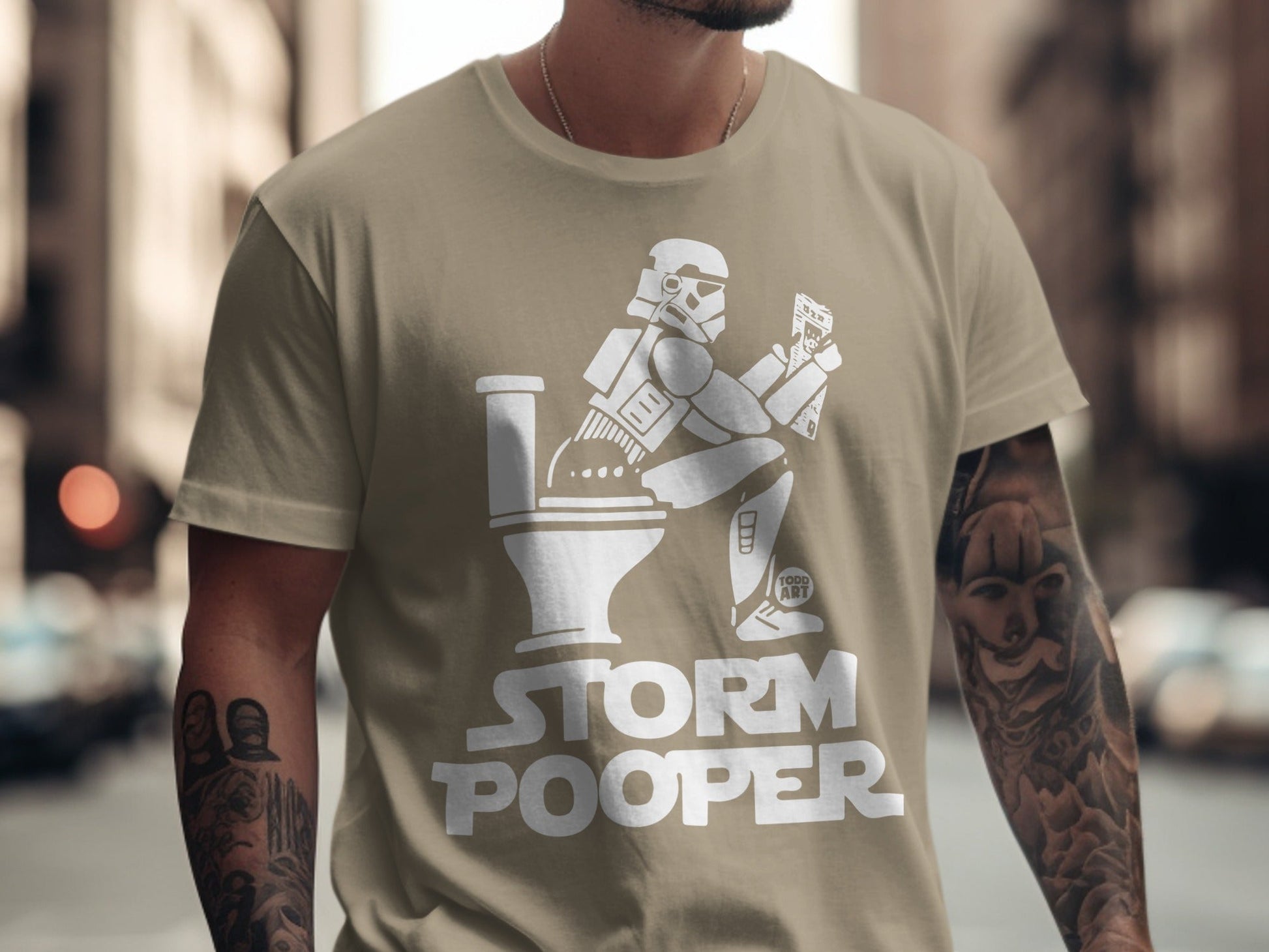 T-shirt with a Stormtrooper sitting on a toilet reading, "STORM POOPER" text.