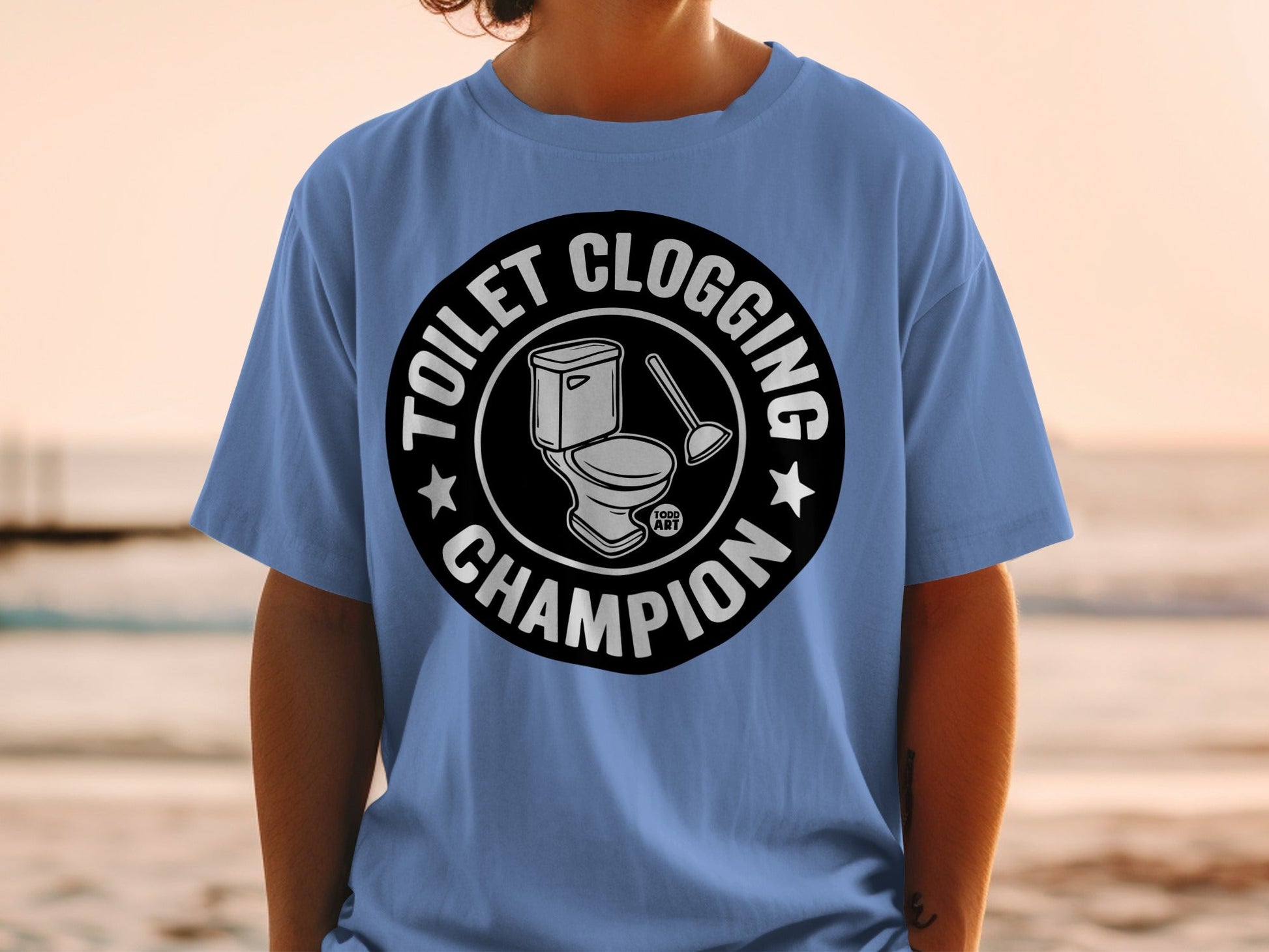 Light blue t-shirt with "Toilet Clogging Champion" and toilet graphic.