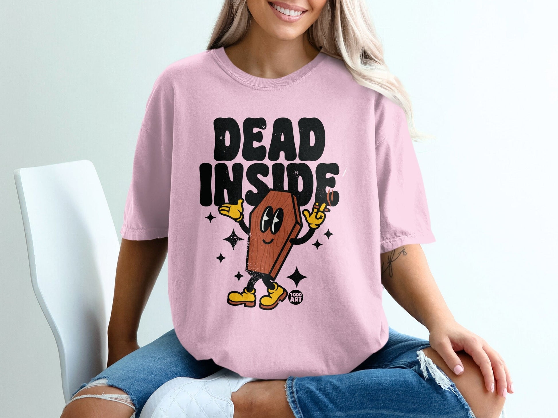 Pink t-shirt with "DEAD INSIDE" text and cartoon coffin character.