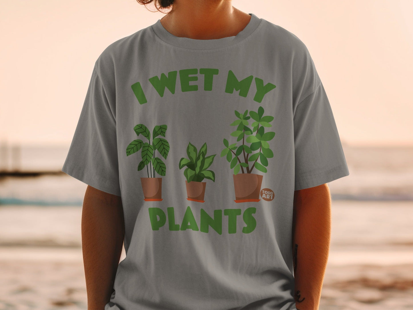 Grey t-shirt with "I WET MY PLANTS" and three potted plants design.