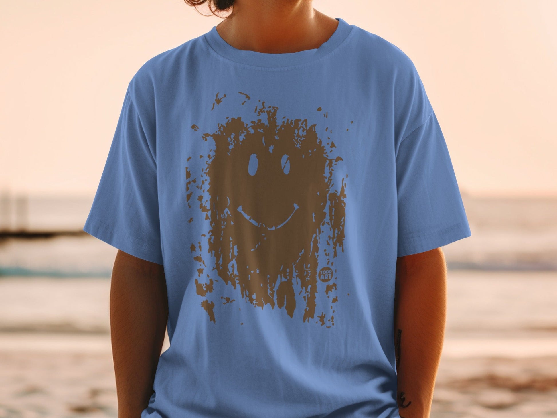 Blue t-shirt with a distressed brown smiley face graphic.