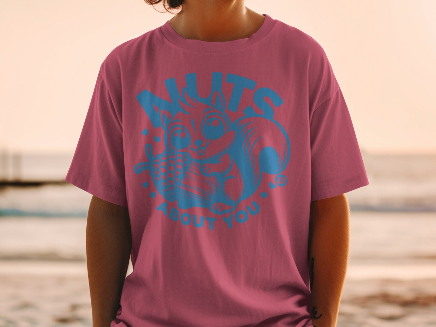 Pink t-shirt with blue cartoon squirrel and text "nuts about you".