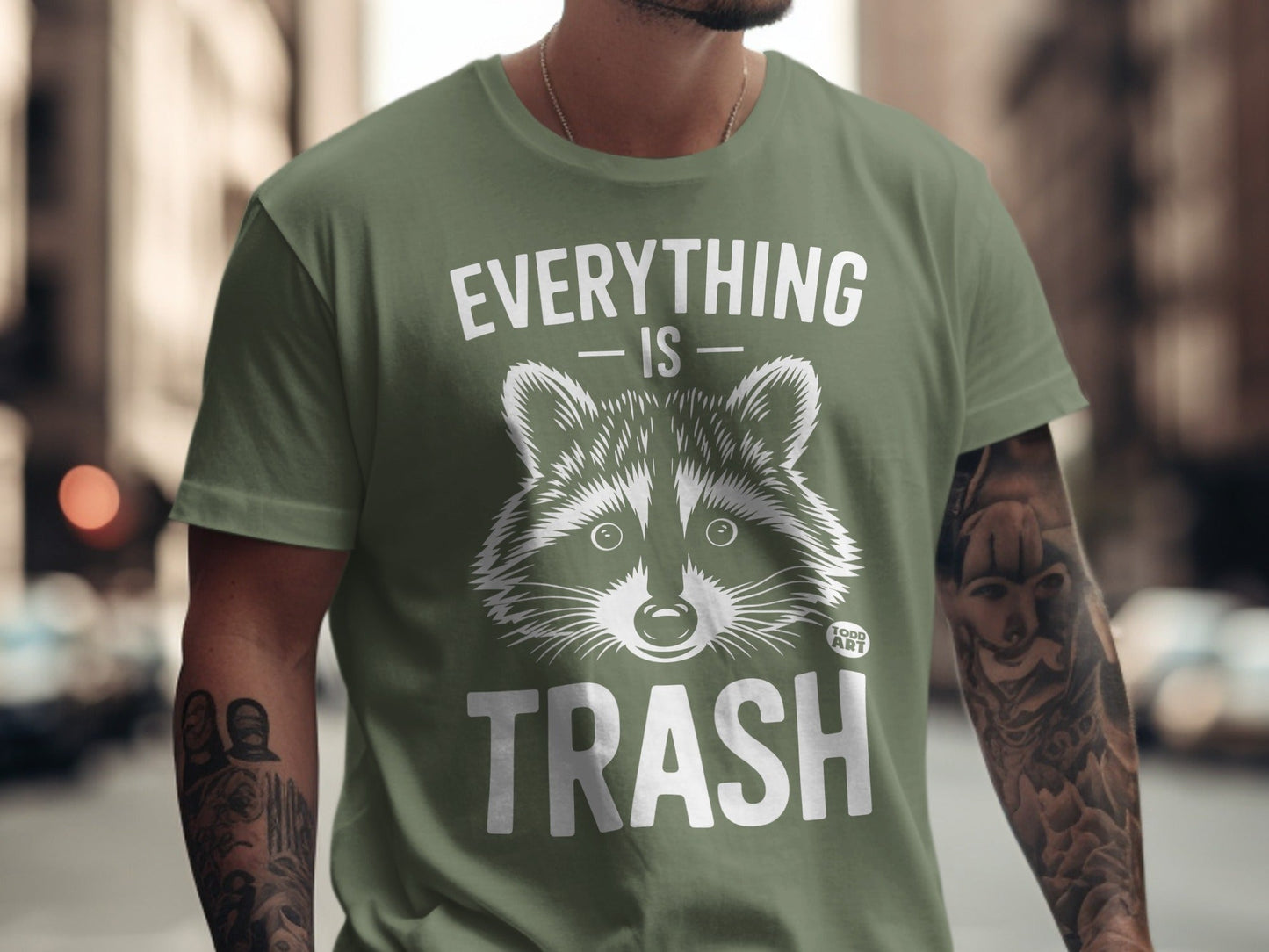 Olive green t-shirt with "EVERYTHING IS TRASH" and raccoon graphic.