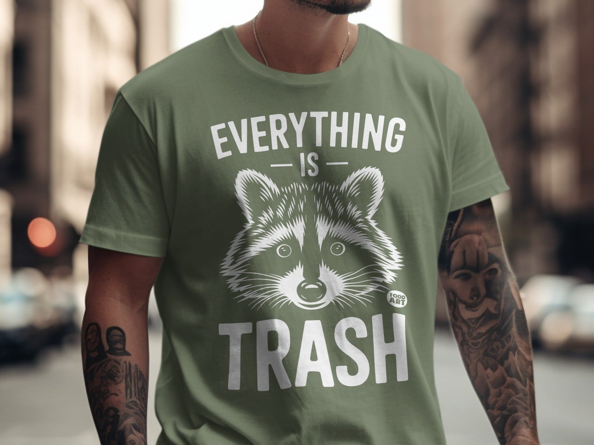 Olive green t-shirt with "EVERYTHING IS TRASH" and raccoon graphic.