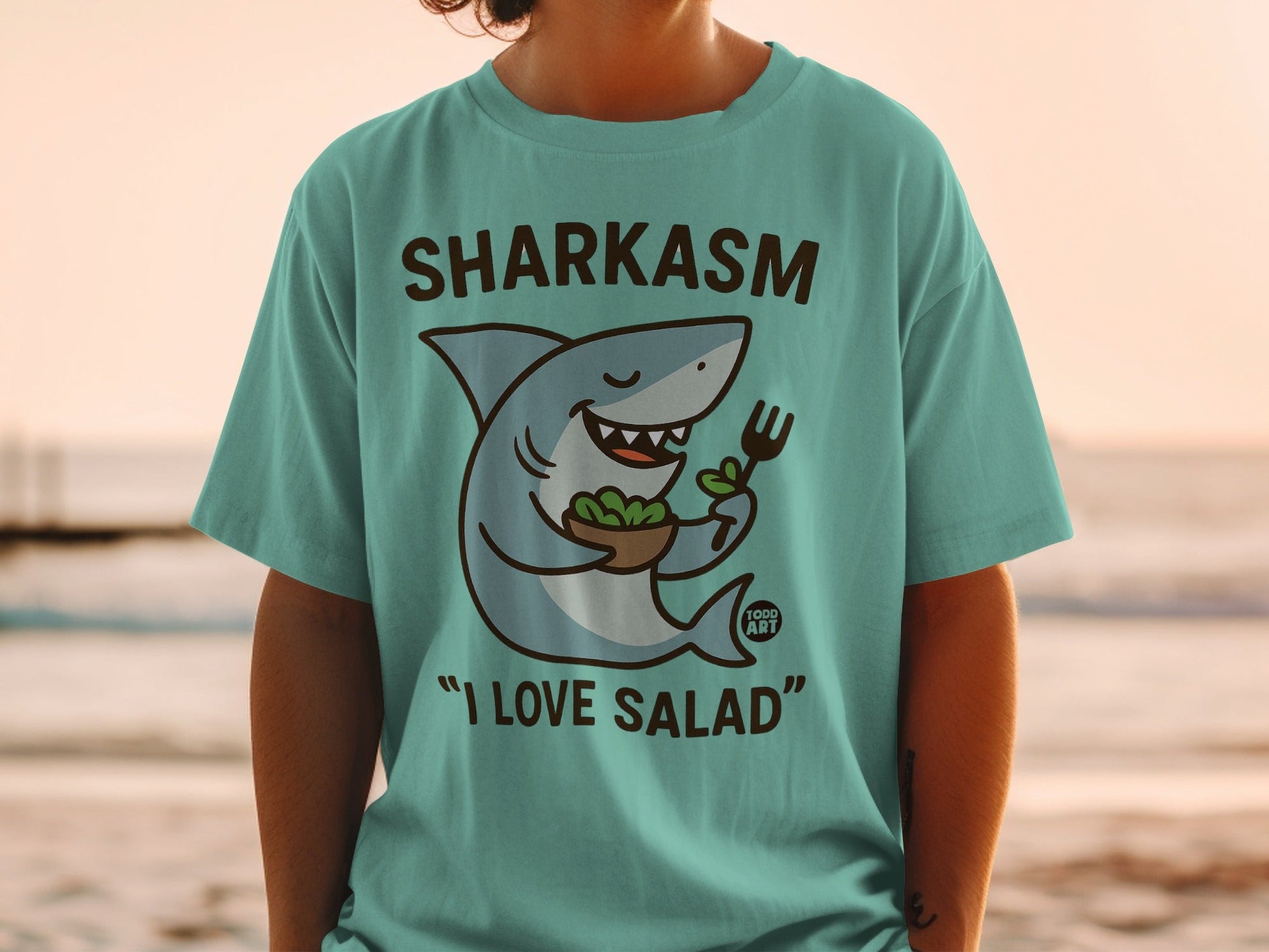 Sharkasm t-shirt with a cartoon shark eating salad, "I love salad".