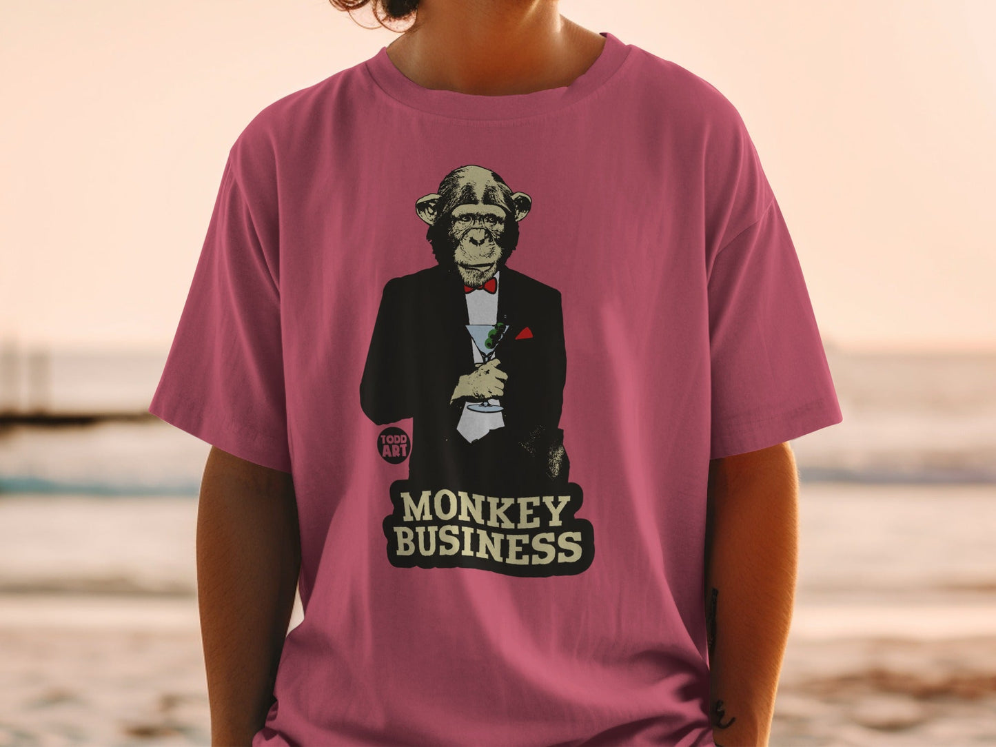 T-shirt with illustration of a chimpanzee in a tuxedo holding a martini, "MONKEY BUSINESS" text.