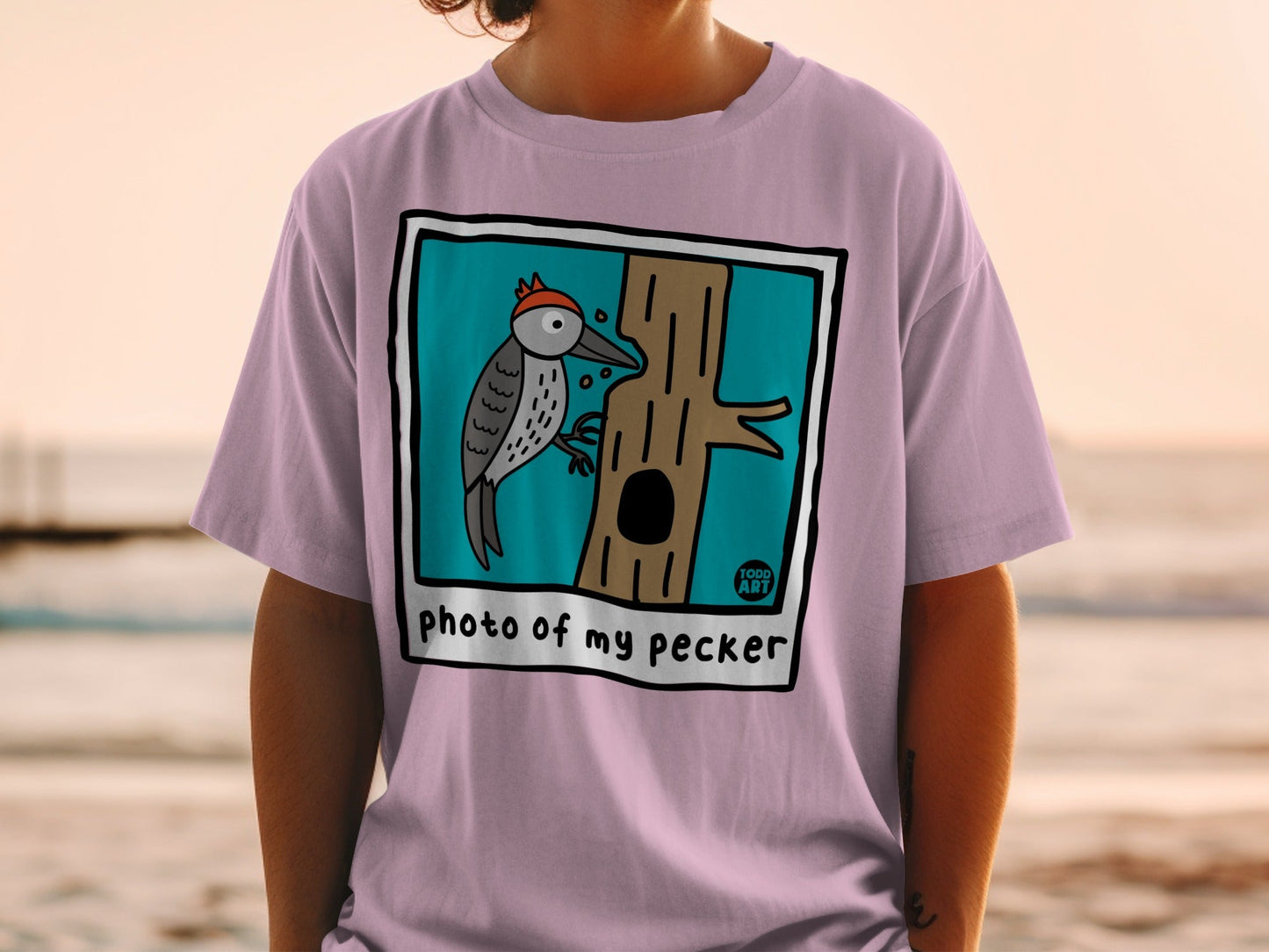 T-shirt with cartoon woodpecker on tree, text "photo of my pecker", 100% ART logo.