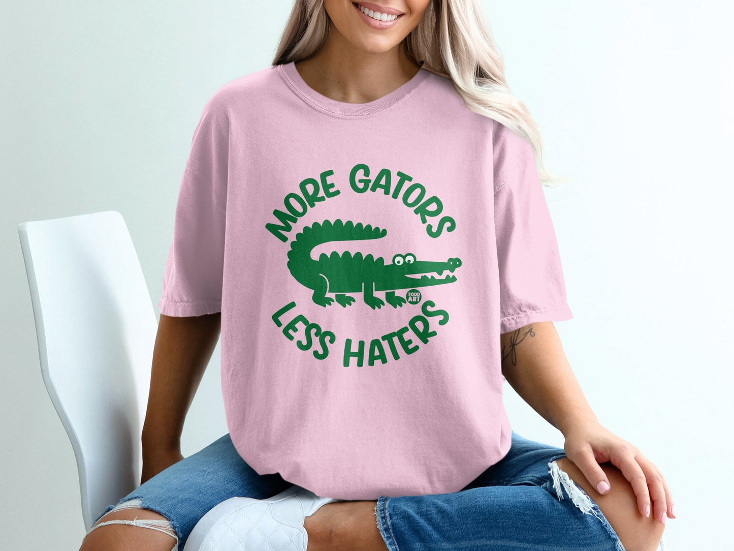 Pink t-shirt with green alligator and text "More Gators Less Haters".