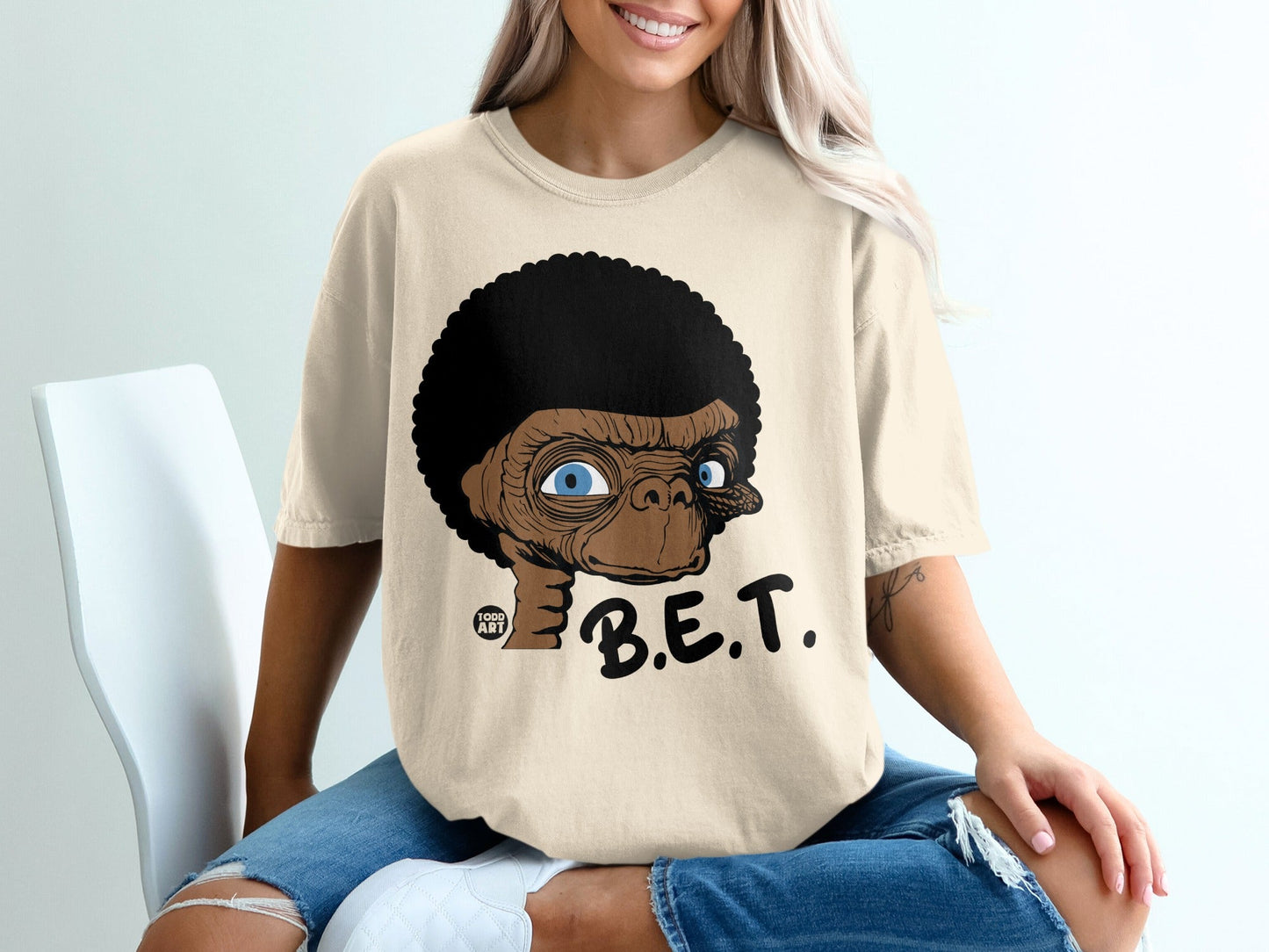 E.T. with an afro hairstyle on a tan t-shirt.