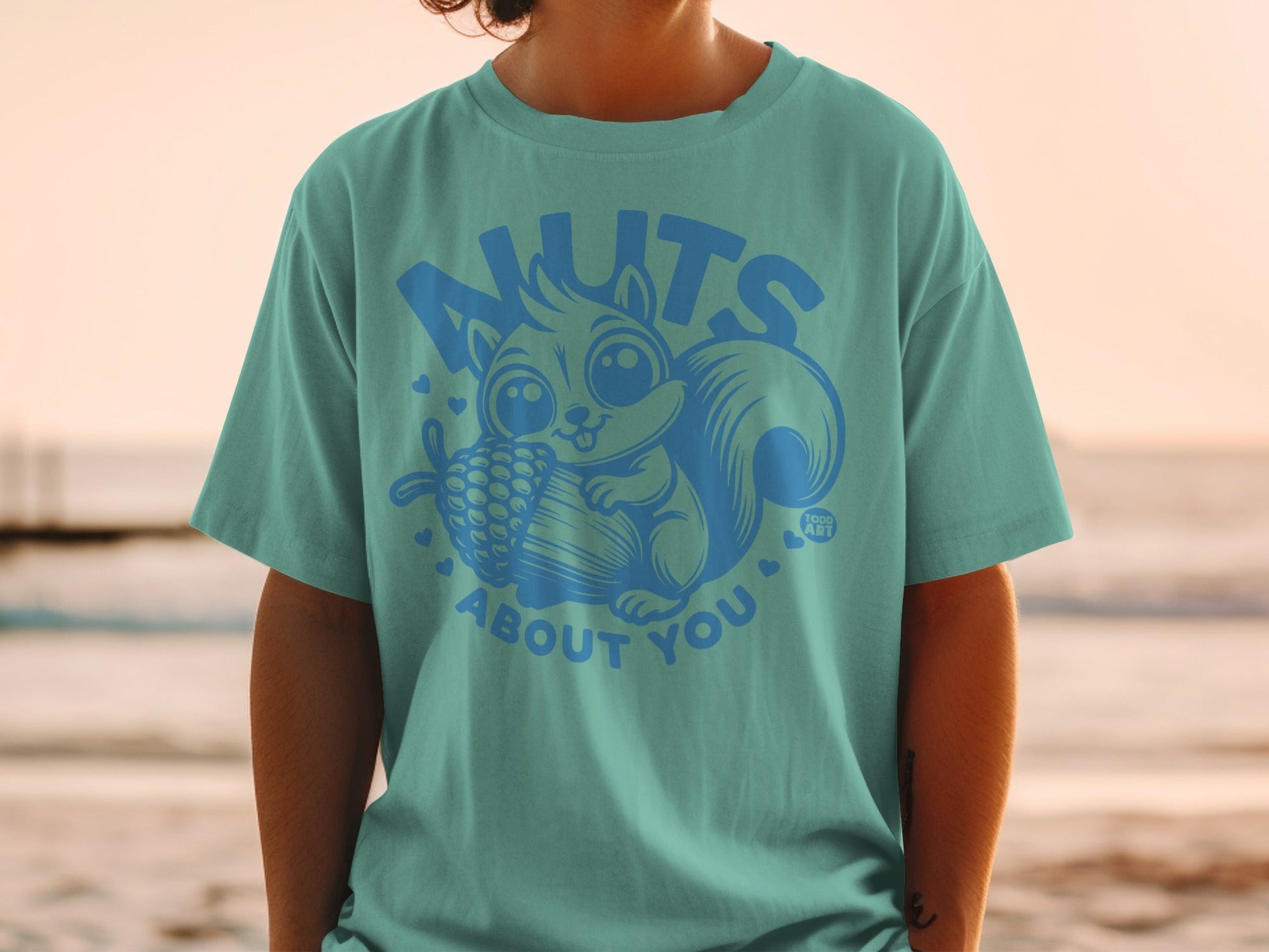 Teal t-shirt with a cartoon squirrel and text "NUTS ABOUT YOU".