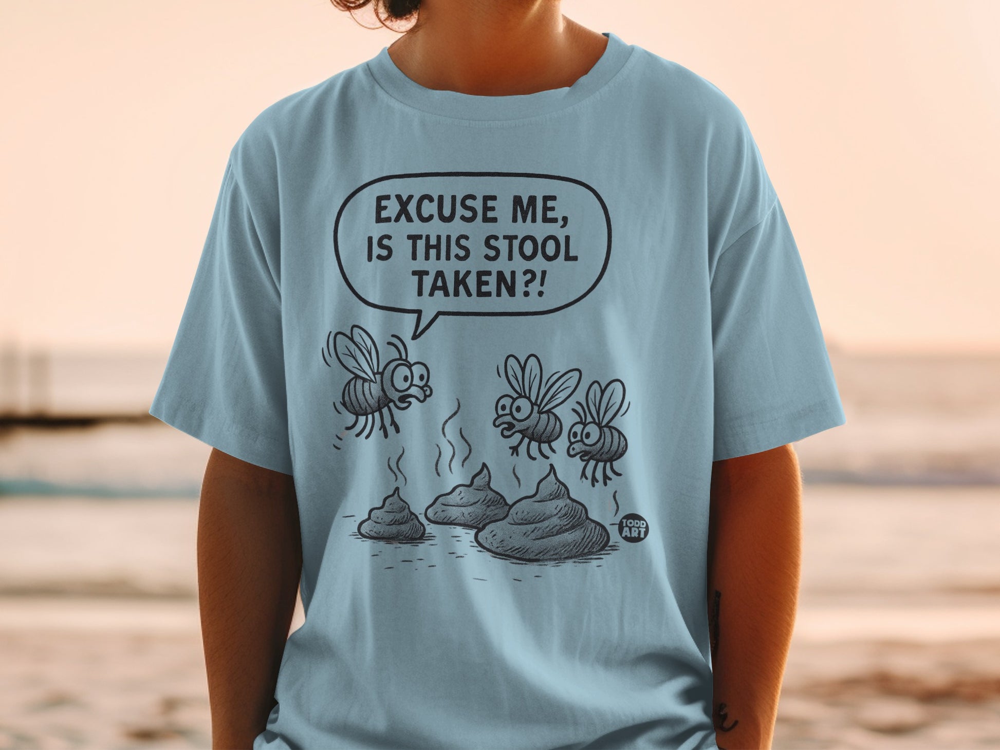Blue t-shirt with cartoon flies questioning a pile of poop.