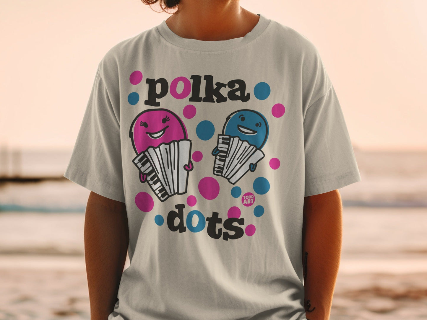 Grey t-shirt with pink and blue polka dot cartoon accordions and "polka dots" text.