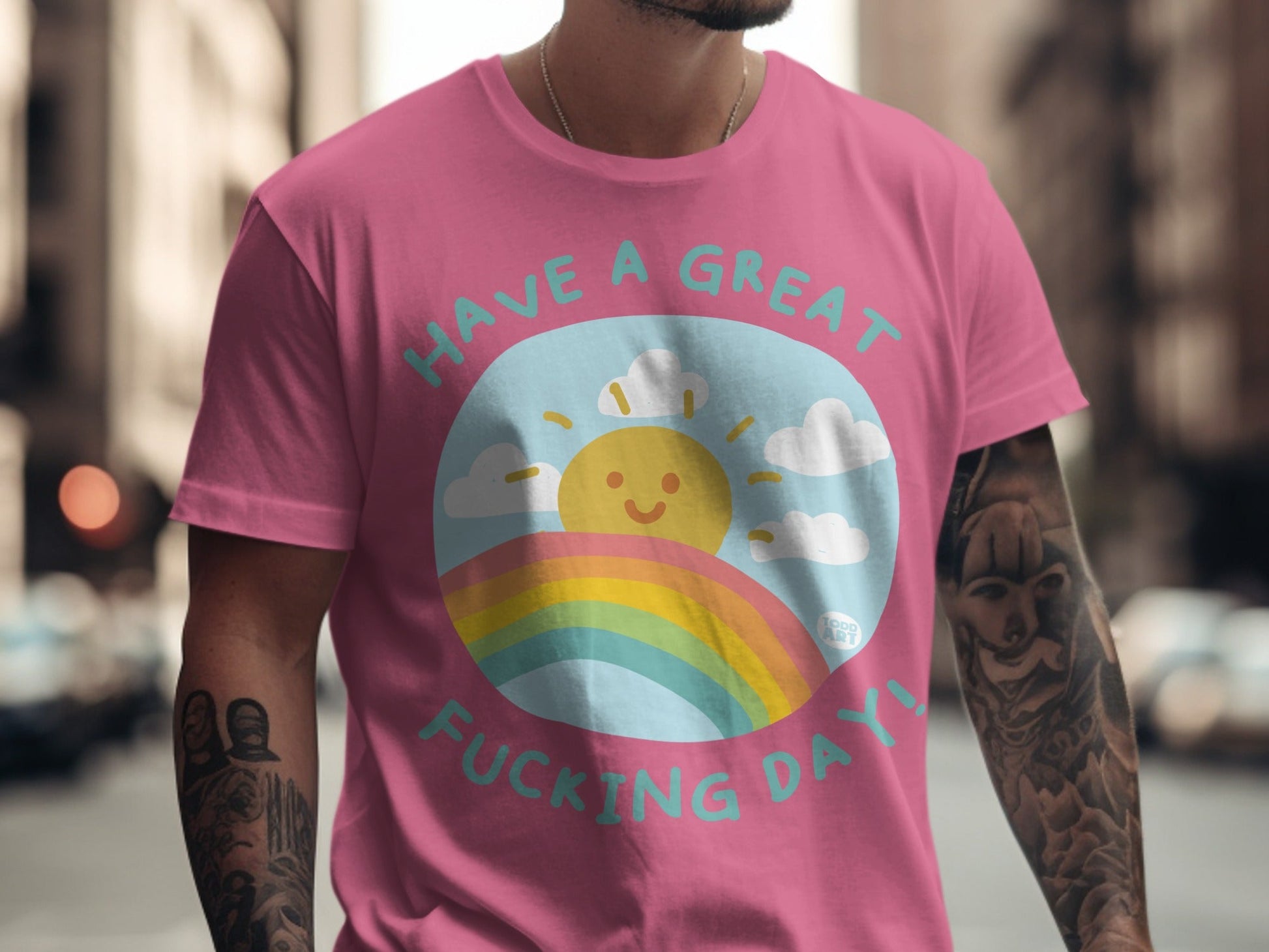 Pink t-shirt with "Have a great fucking day!" text, sun, and rainbow design.