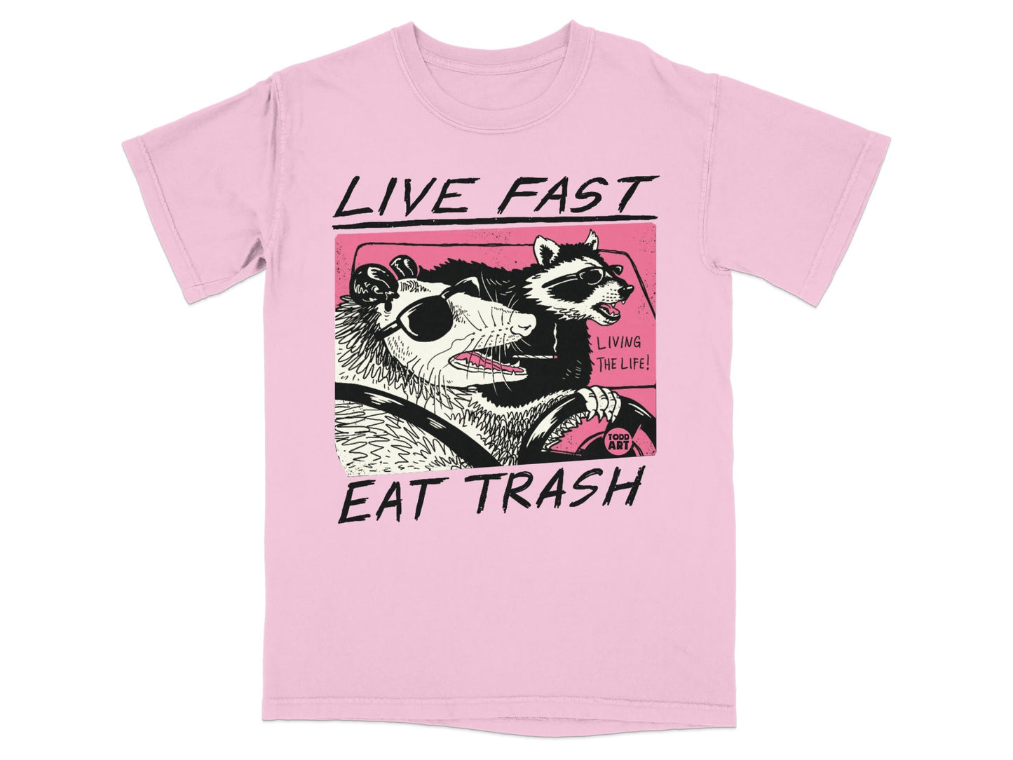 Pink t-shirt with graphic of a raccoon and opossum driving a car.
