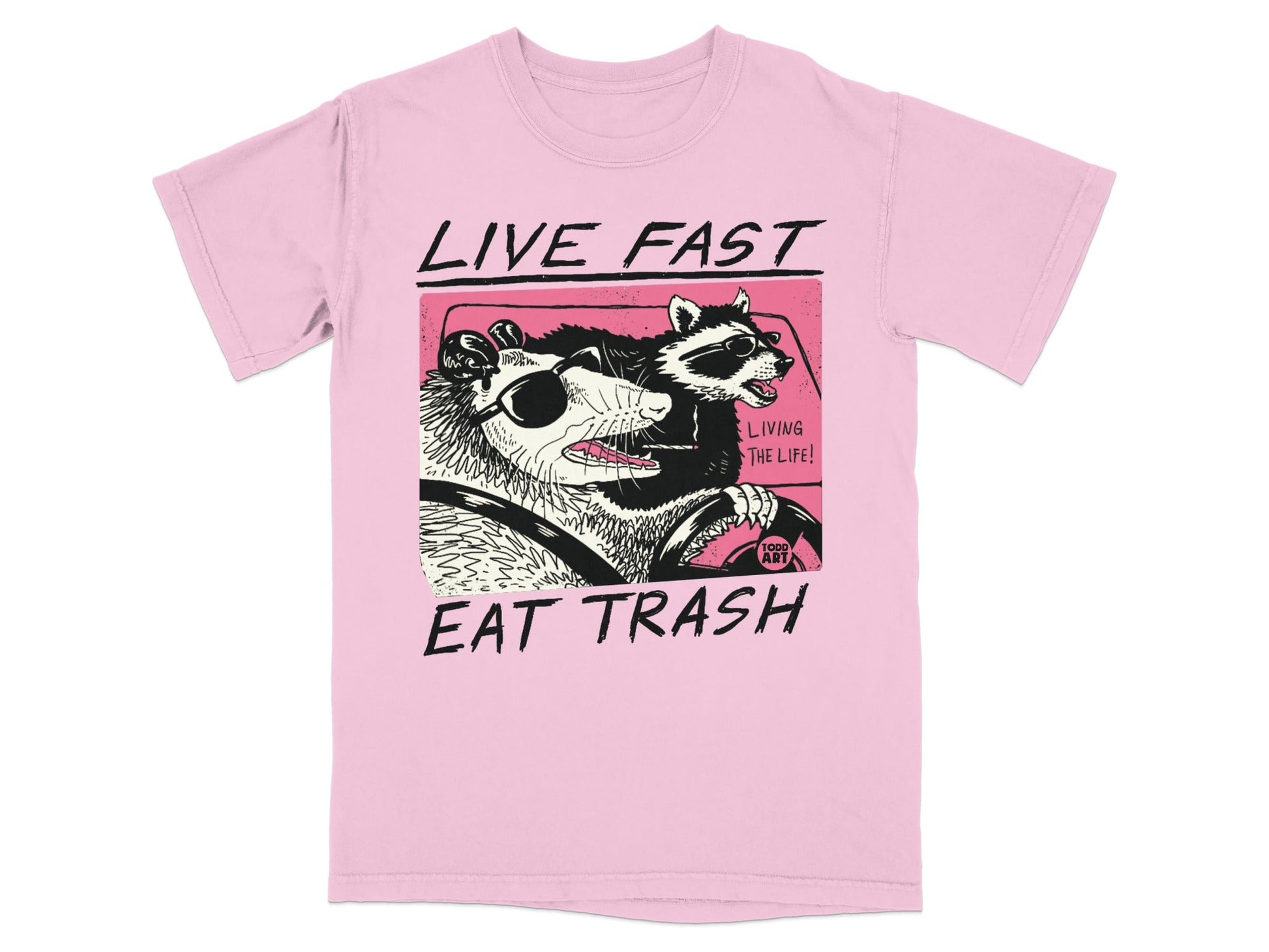 Pink t-shirt with graphic of a raccoon and opossum driving a car.