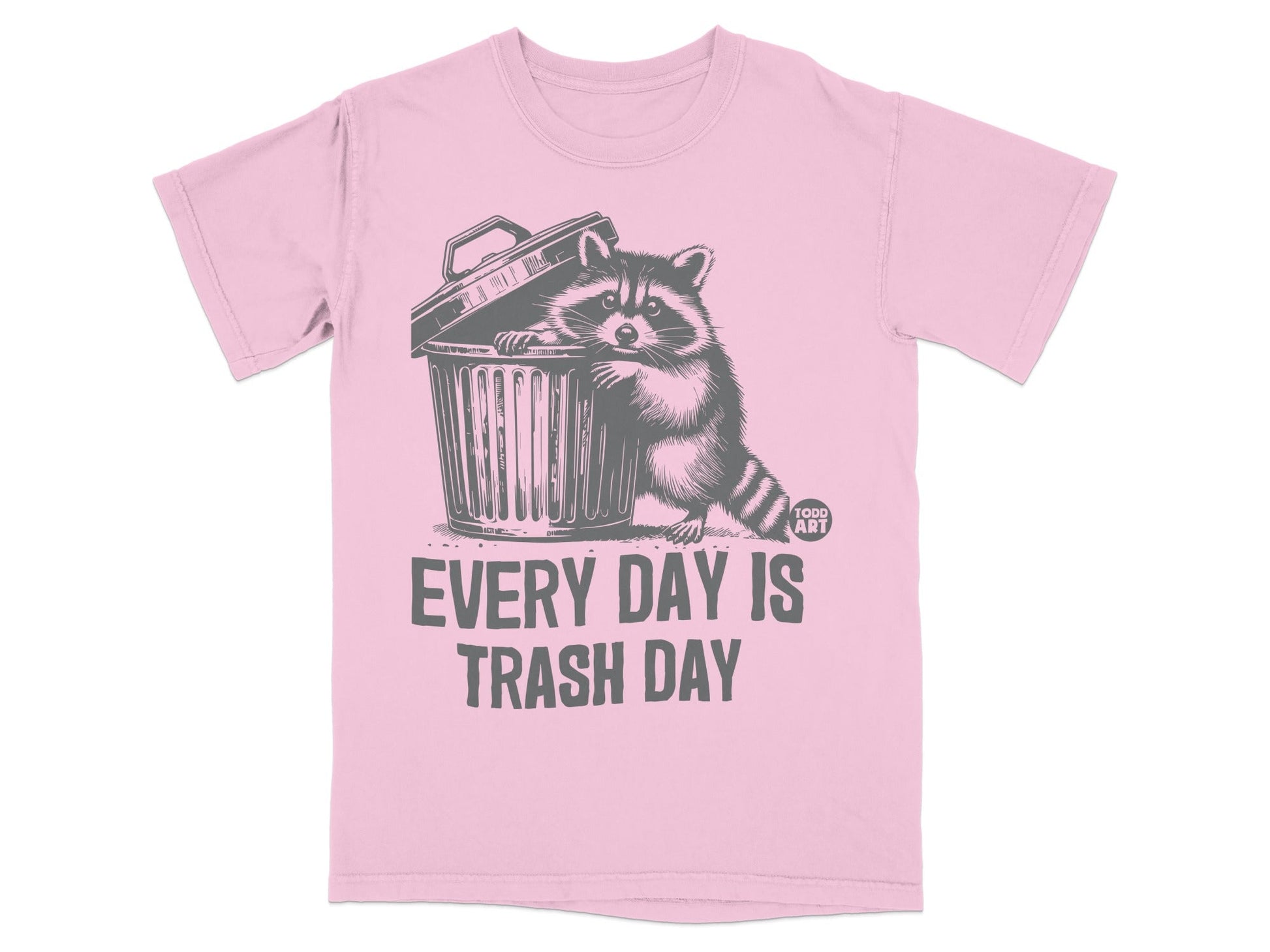 Pink t-shirt with raccoon peeking out of trash can, "EVERY DAY IS TRASH DAY" text.