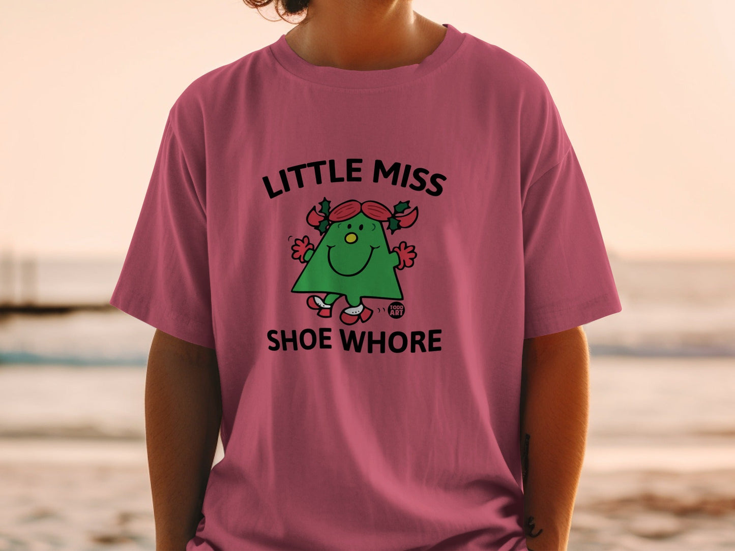 Little Miss Shoe Whore graphic t-shirt with cartoon character and text.