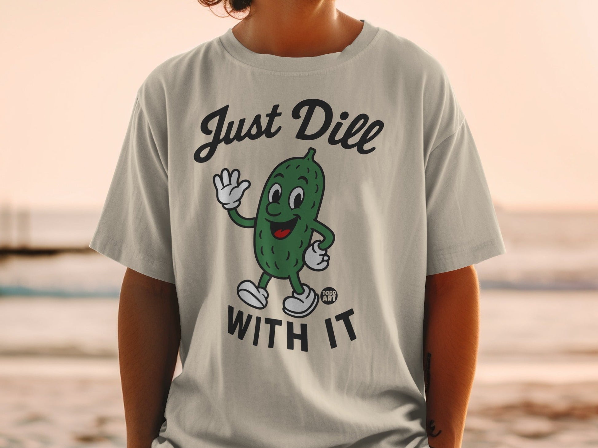 T-shirt with a cartoon pickle waving and the text "Just Dill With It."