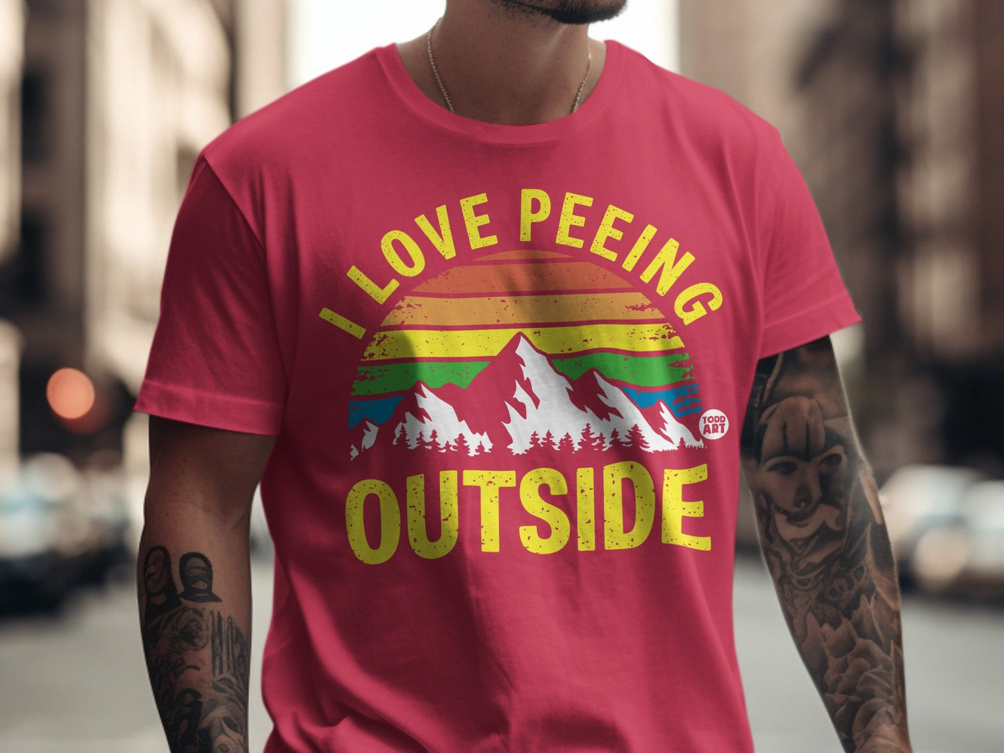 Red t-shirt with "I LOVE PEING OUTSIDE" text and rainbow mountain graphic.