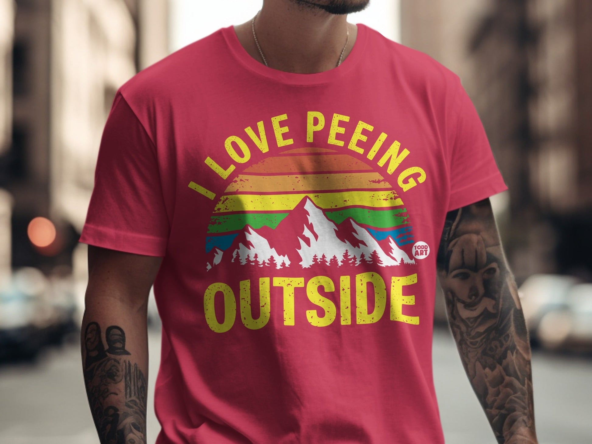 Red t-shirt with "I LOVE PEING OUTSIDE" text and rainbow mountain graphic.