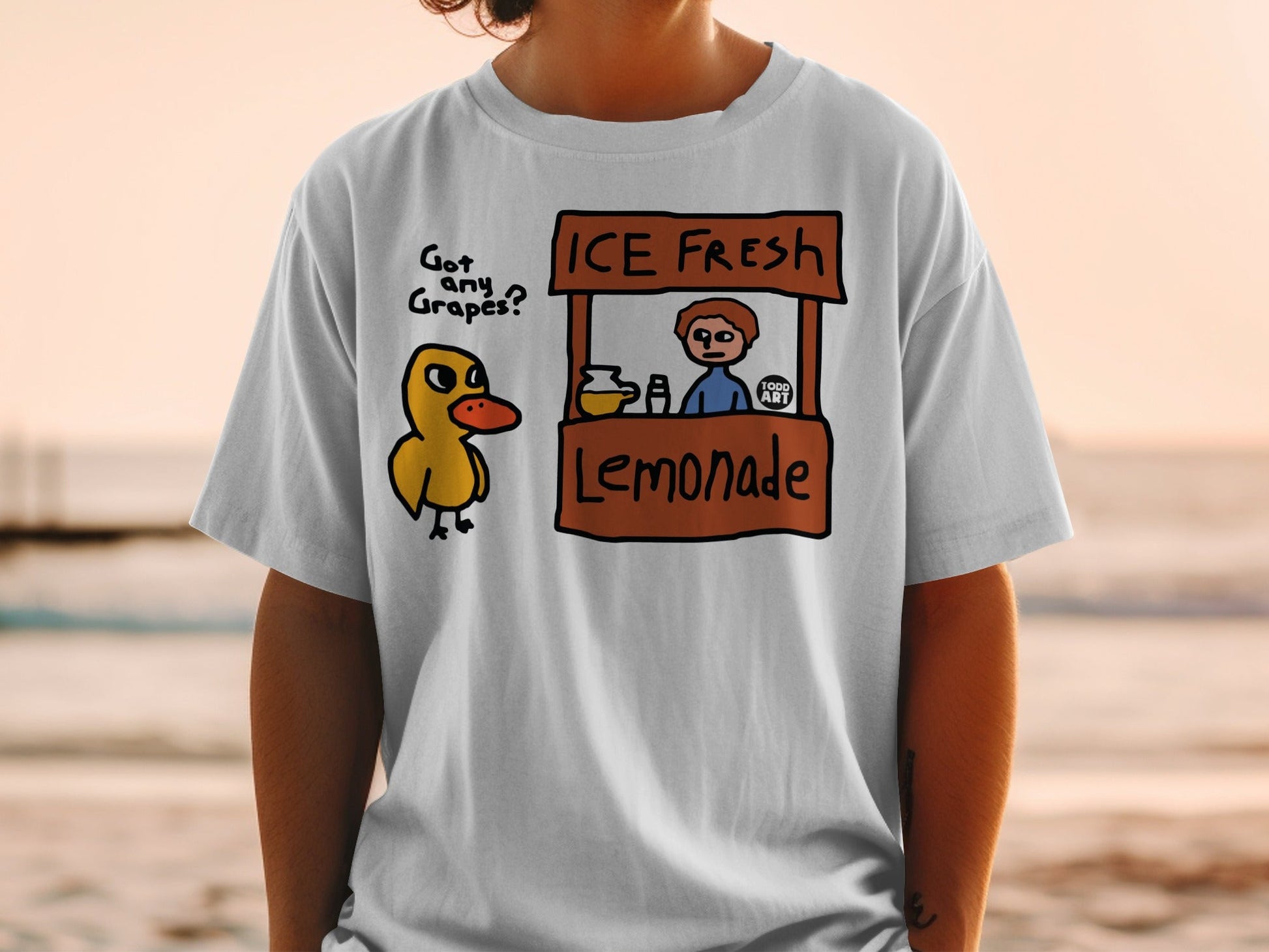 T-shirt with duck and lemonade stand design, text reads "Got any Grapes? ICE FRESH Lemonade".
