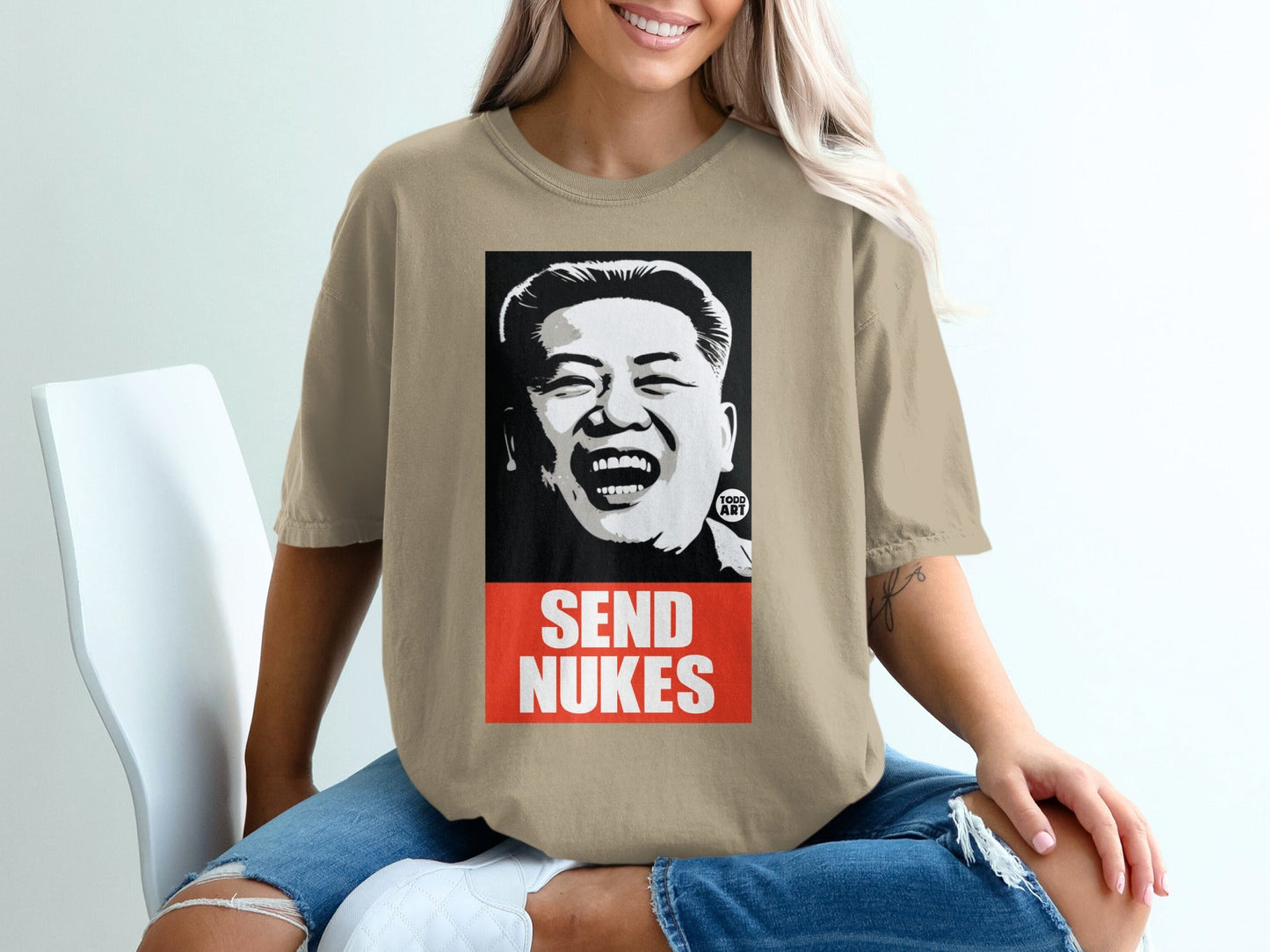 T-shirt with portrait of a laughing Kim Jong Un, text "SEND NUKES".
