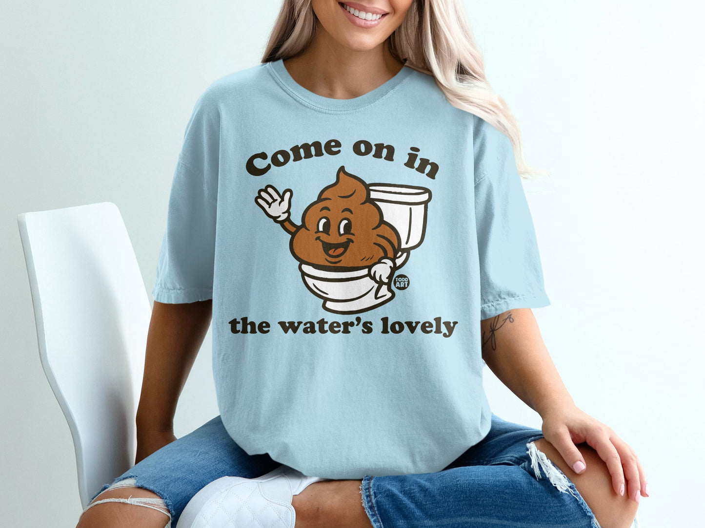 Light blue t-shirt with smiling toilet paper roll saying "Come on in the water's lovely."