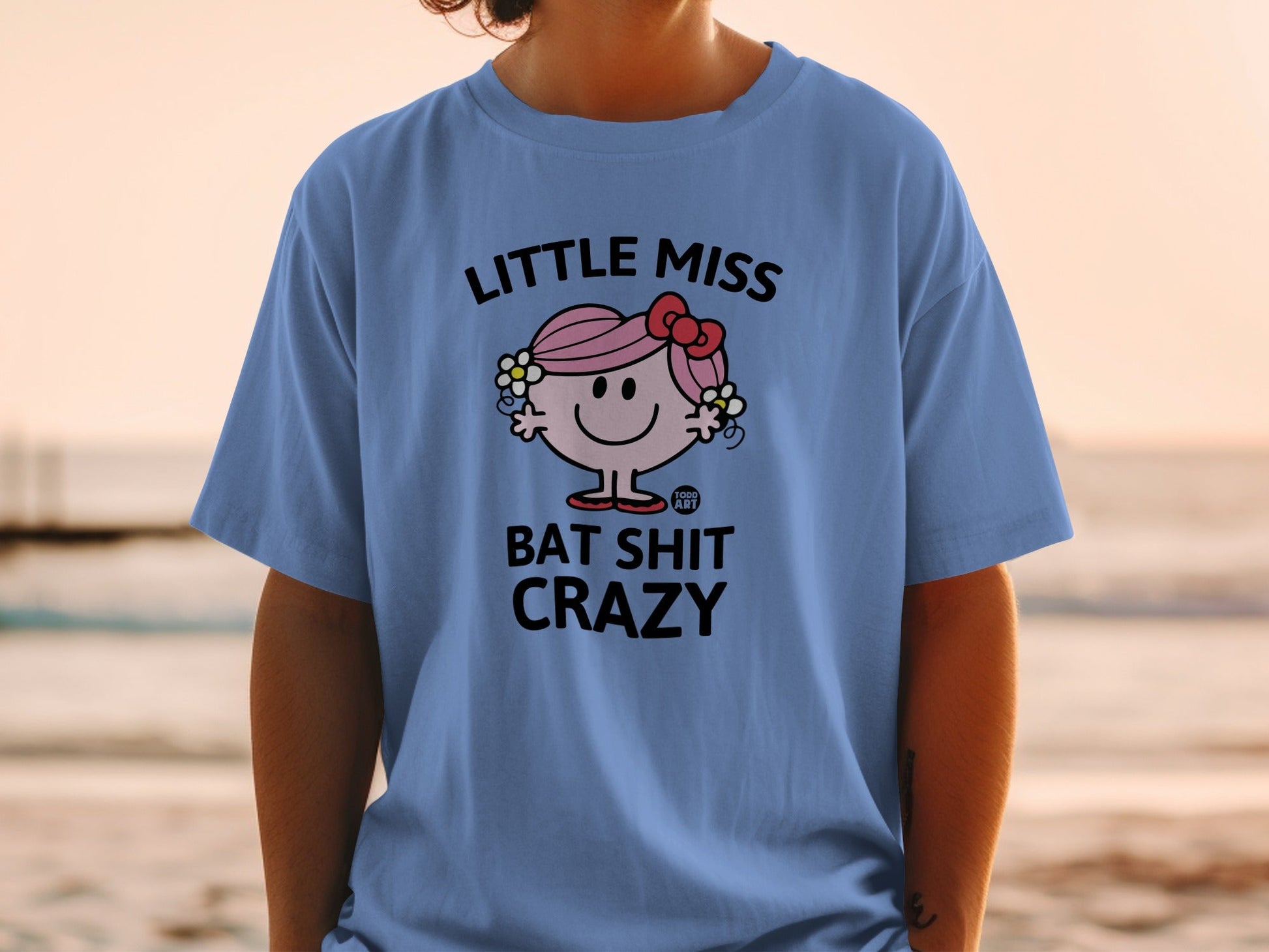 Light blue t-shirt with "Little Miss Bat Shit Crazy" text and character.