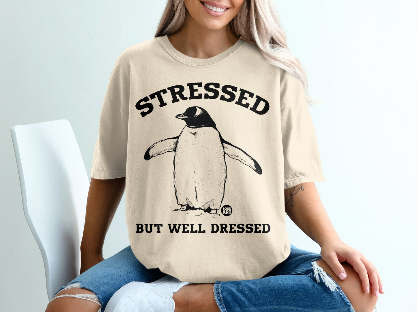 T-shirt with a penguin graphic and "Stressed But Well Dressed" text.