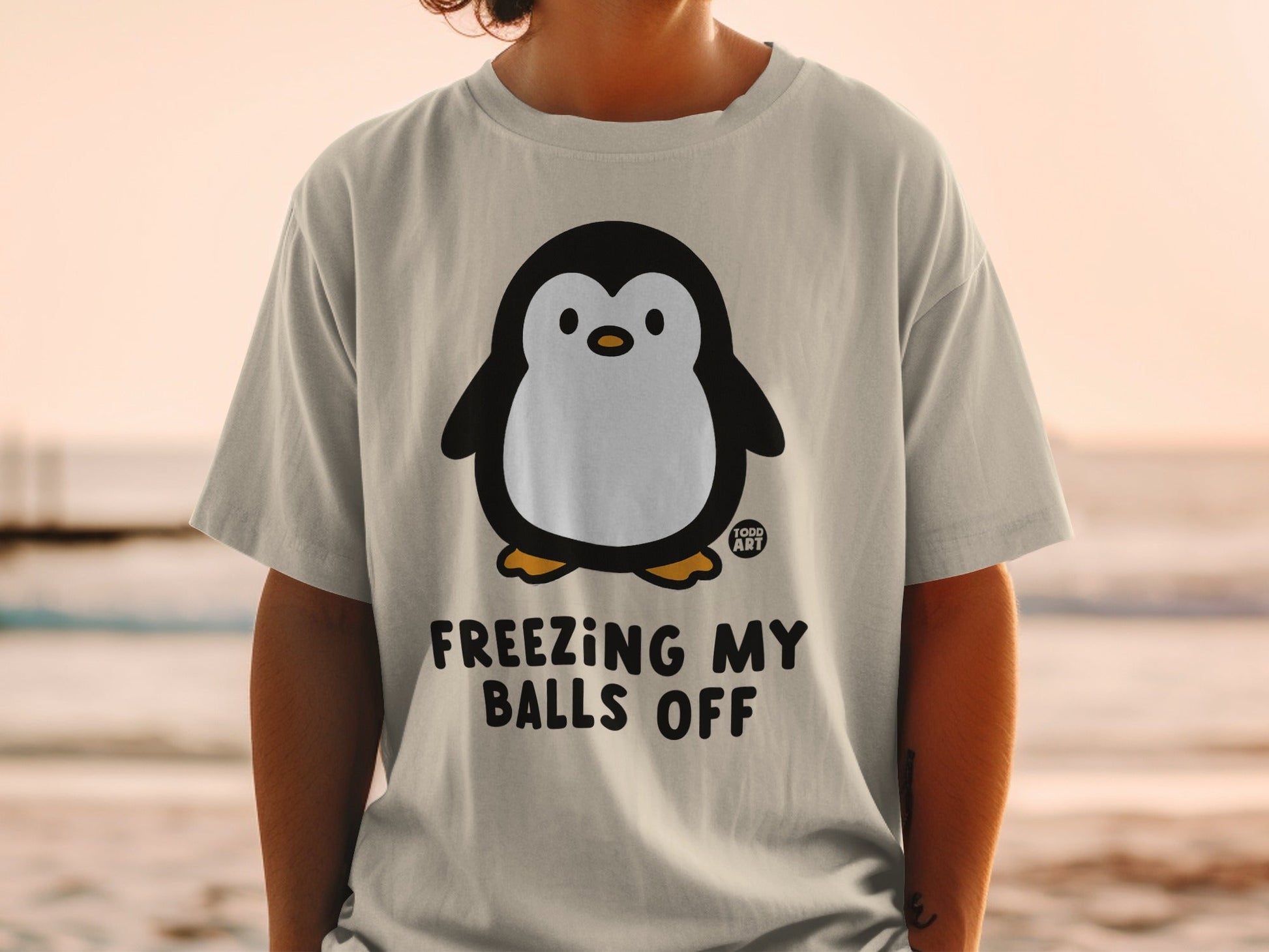 T-shirt with a cartoon penguin and text "FREEZING MY BALLS OFF".