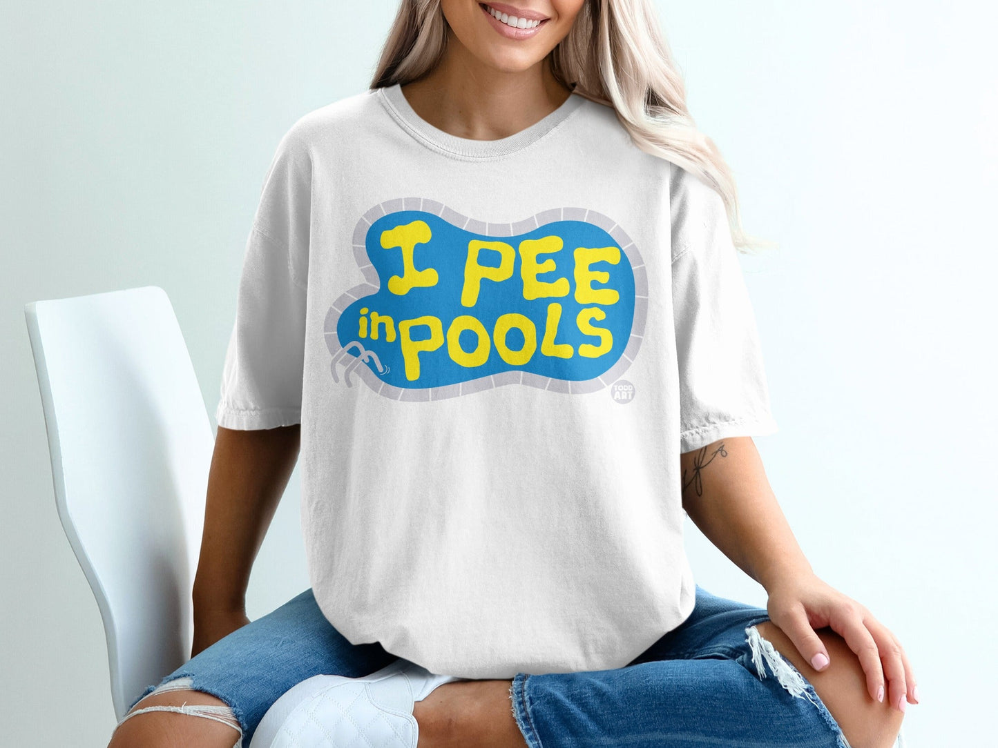 White t-shirt with blue pool graphic and yellow text "I PEE IN POOLS".