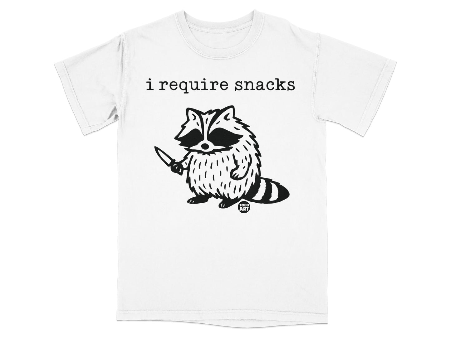 T-shirt with a raccoon holding a knife and the text "i require snacks".