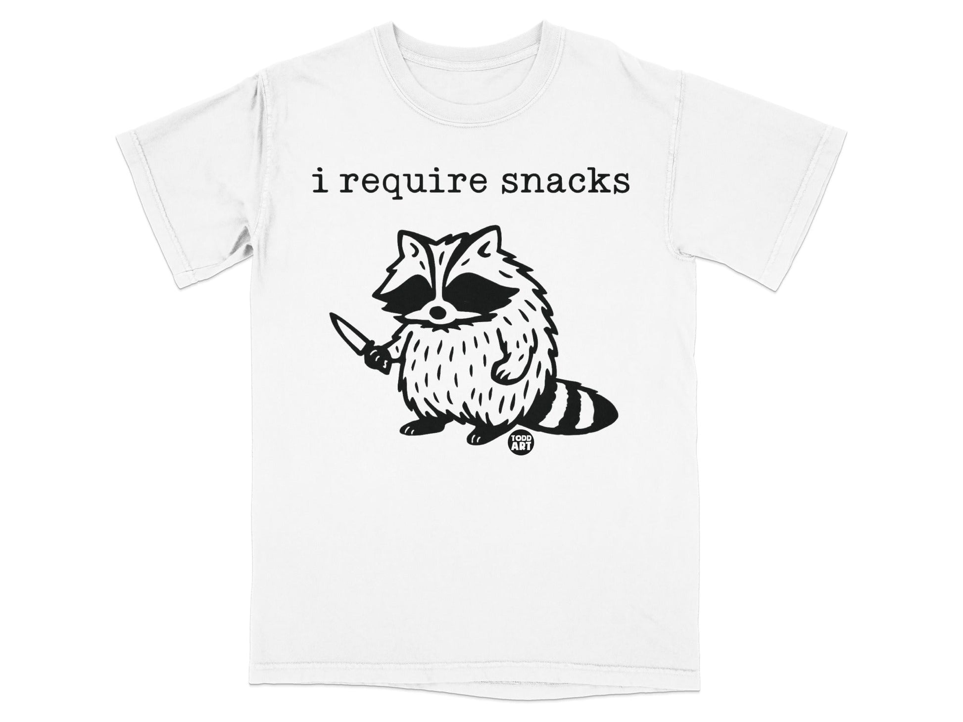 T-shirt with a raccoon holding a knife and the text "i require snacks".