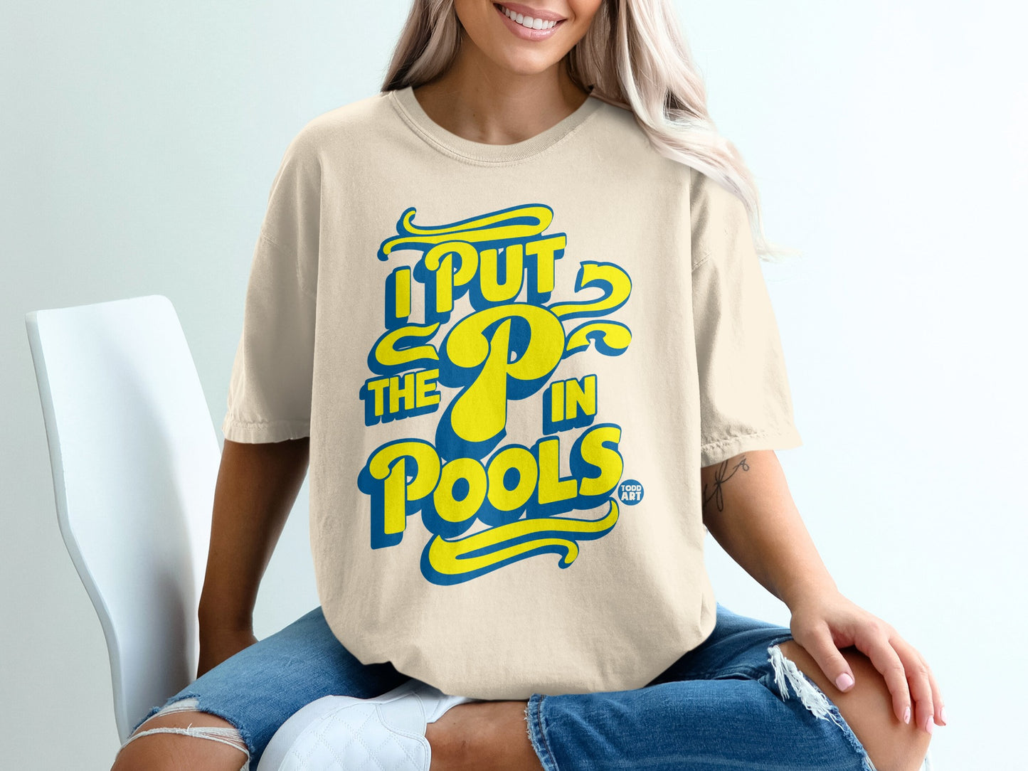 Cream t-shirt with yellow and blue text "I PUT THE P IN POOLS".